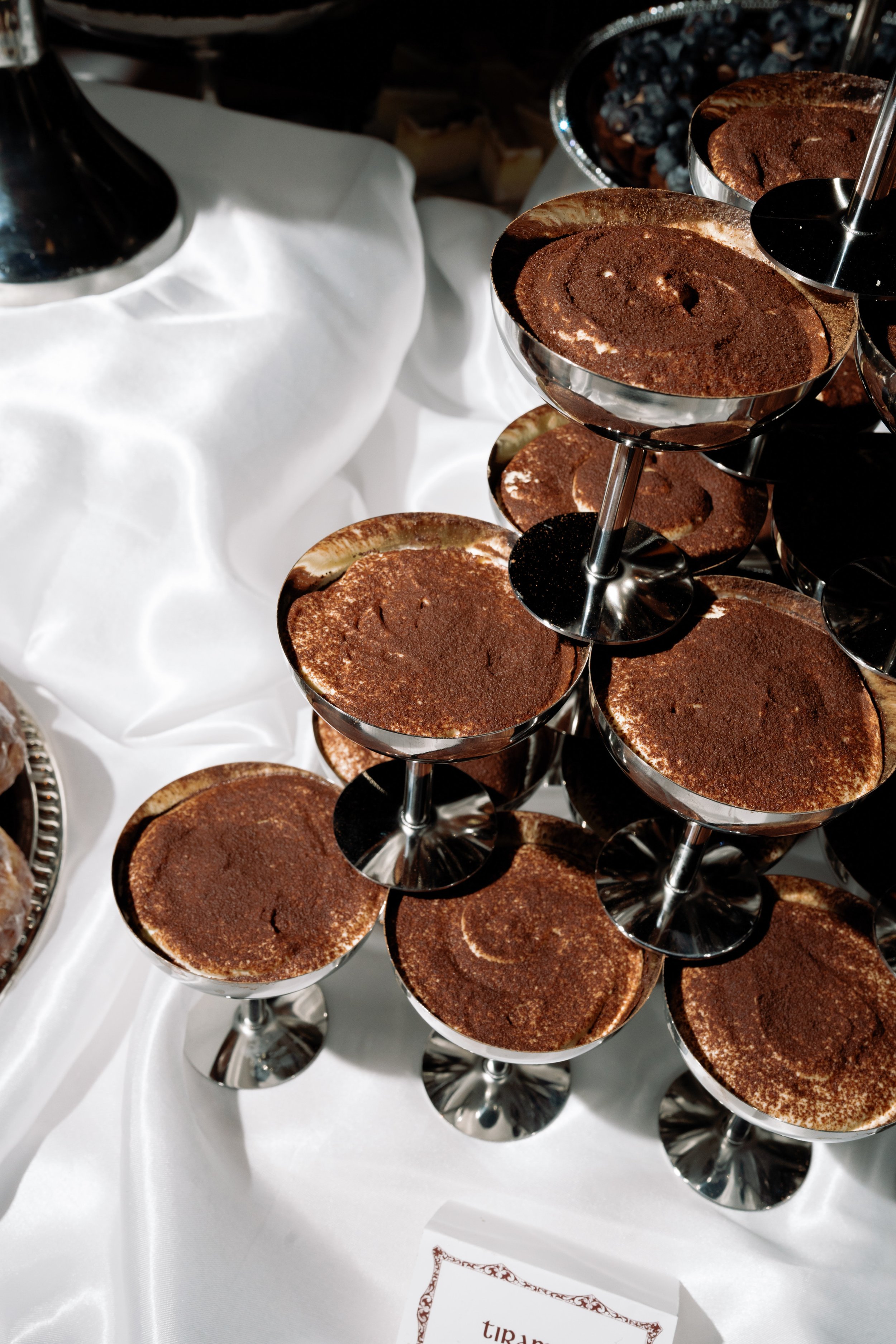 Close-up of tiramisu served in vintage coupe glasses at the dessert table