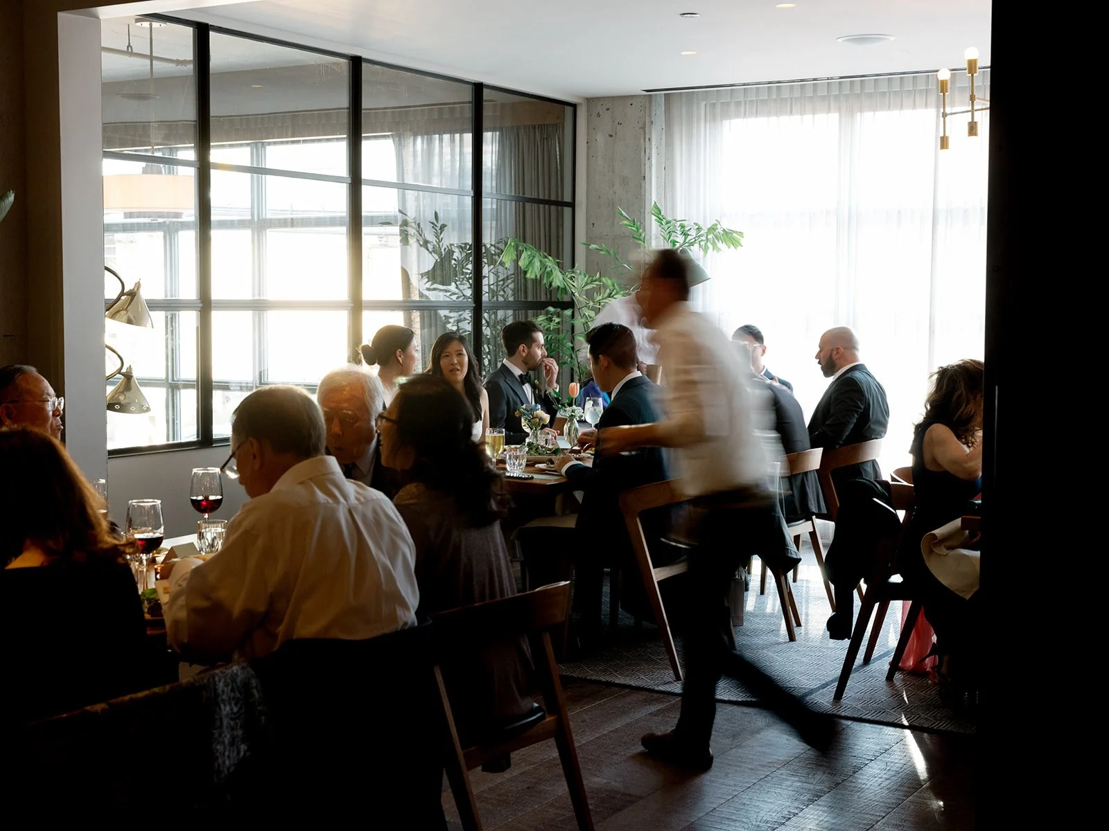 The Hoxton Chicago dining room alive with the energy of a wedding reception — warm light, servers in motion, guests caught mid-conversation. It feels like a dinner party at the best restaurant in the city, because it is.