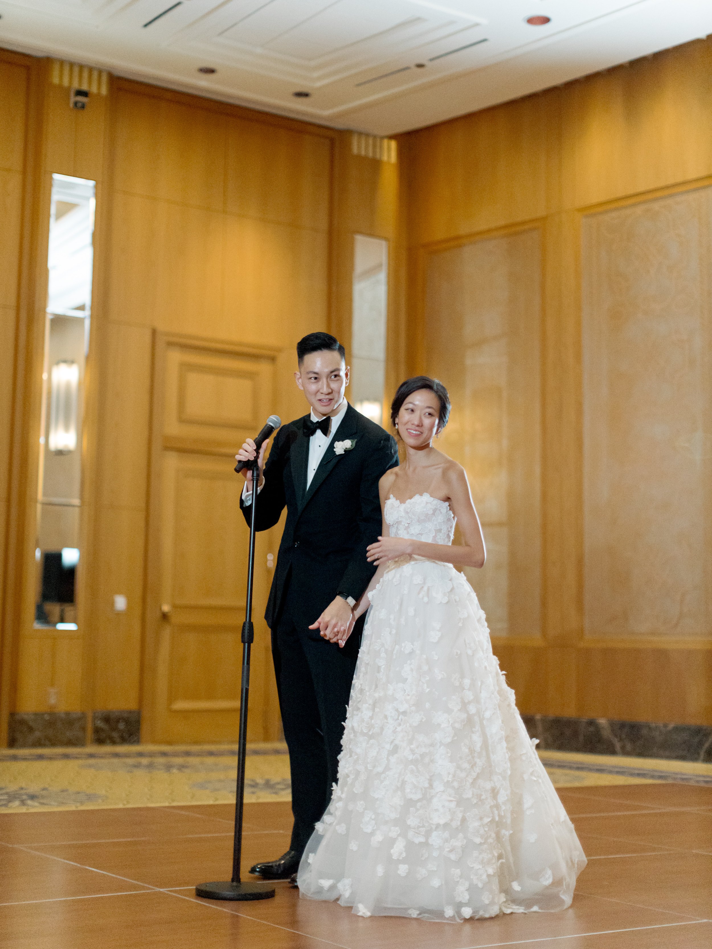 Bride and groom share a microphone to give a speech at their wedding reception at The Peninsula Chicago