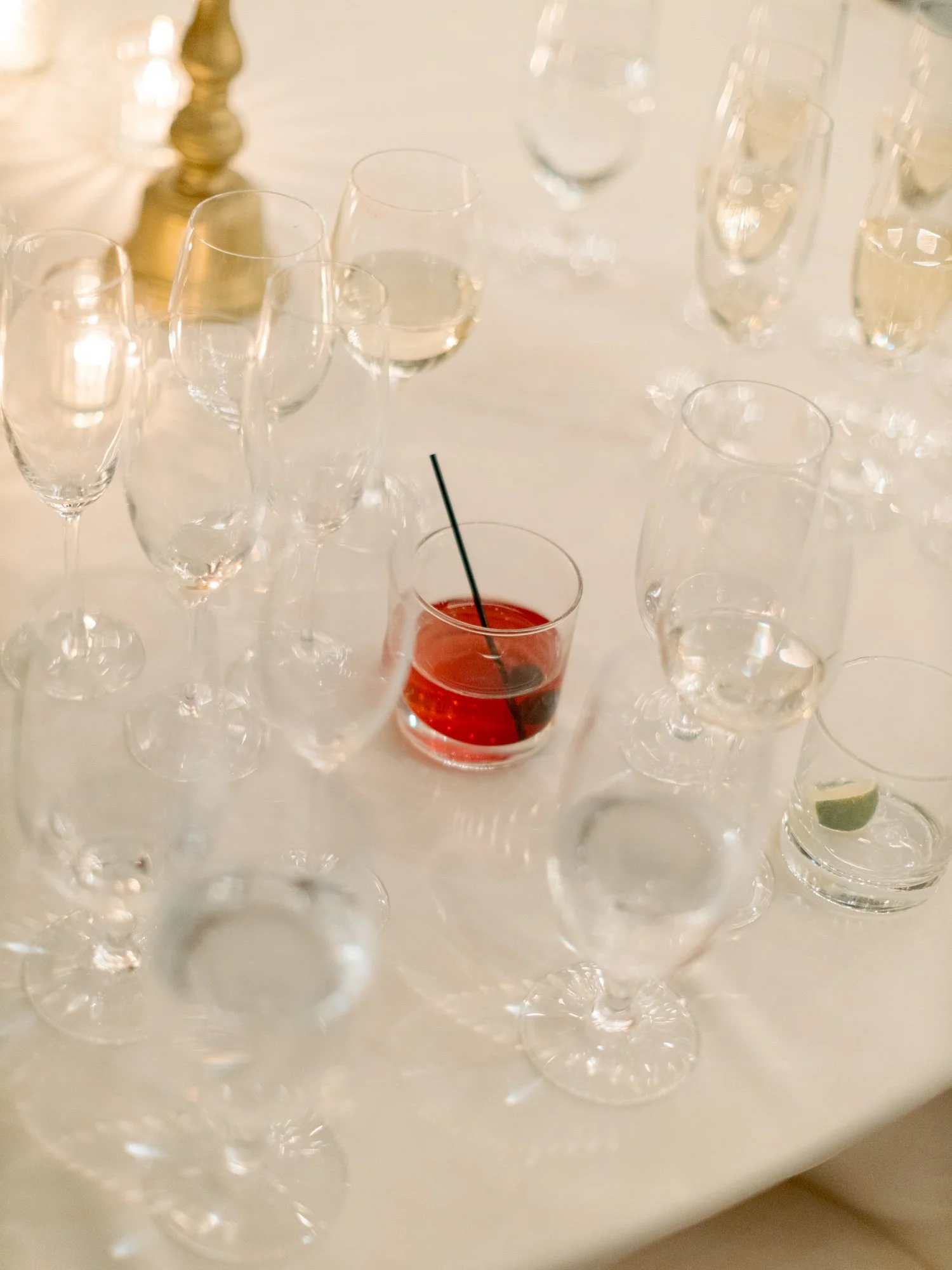 A refined reception table detail at the Chicago Illuminating Company, champagne flutes and wine glasses arranged elegantly around a single bright red cocktail.