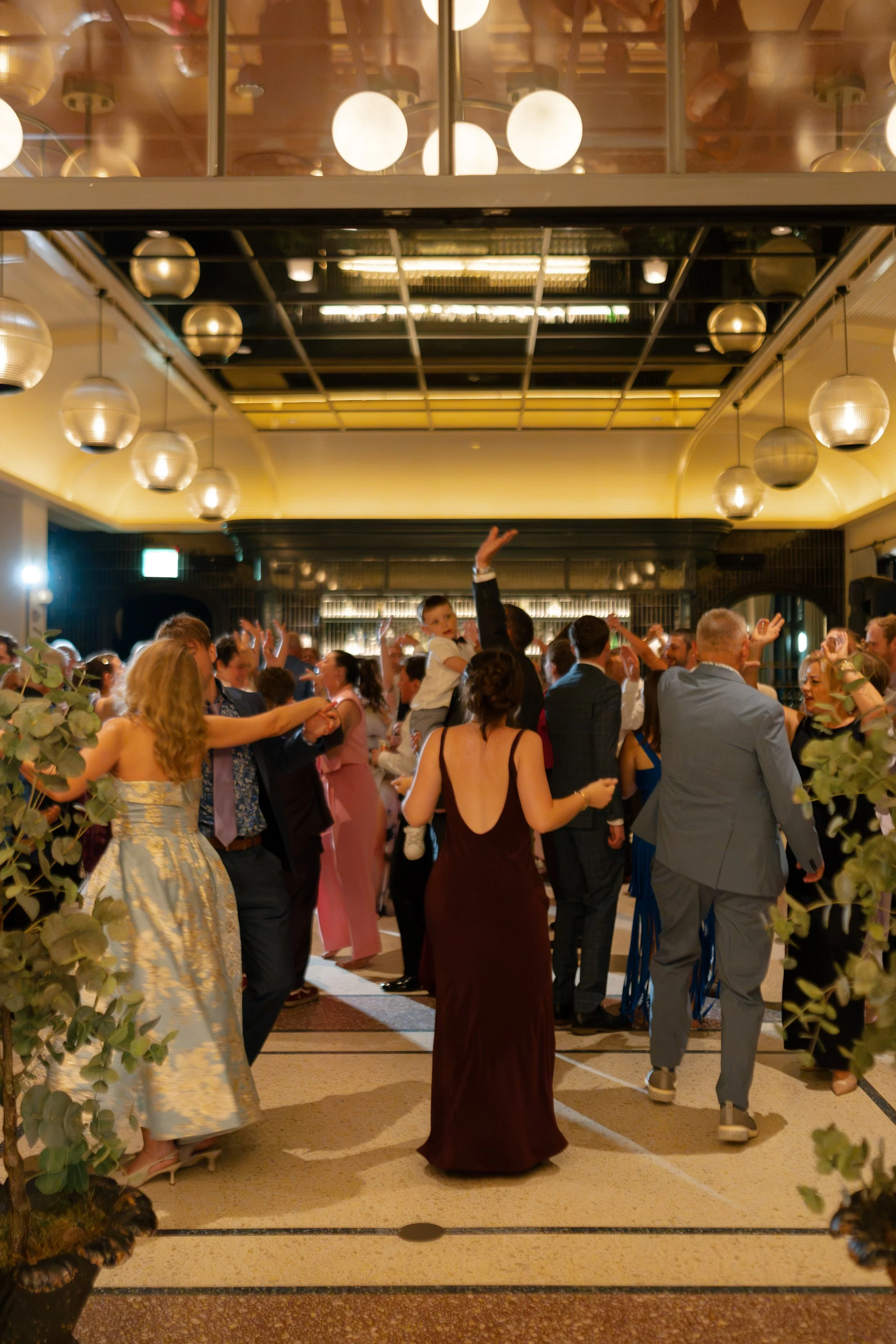 Guests dance and celebrate together in the hotel lobby at night