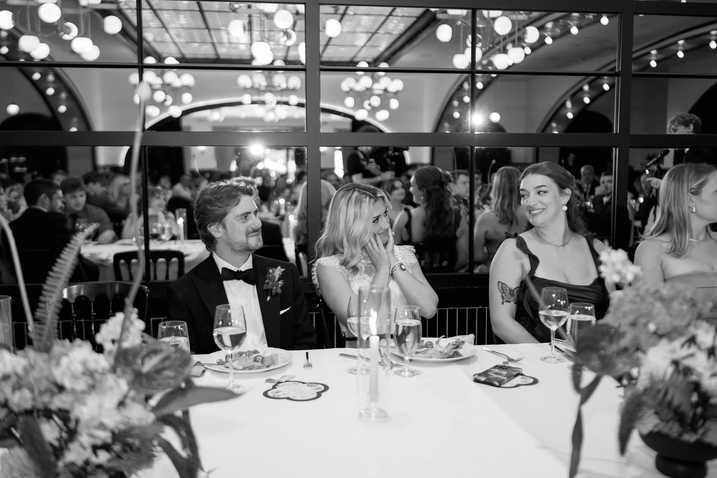Black and white wide shot of the reception dining room set for the evening