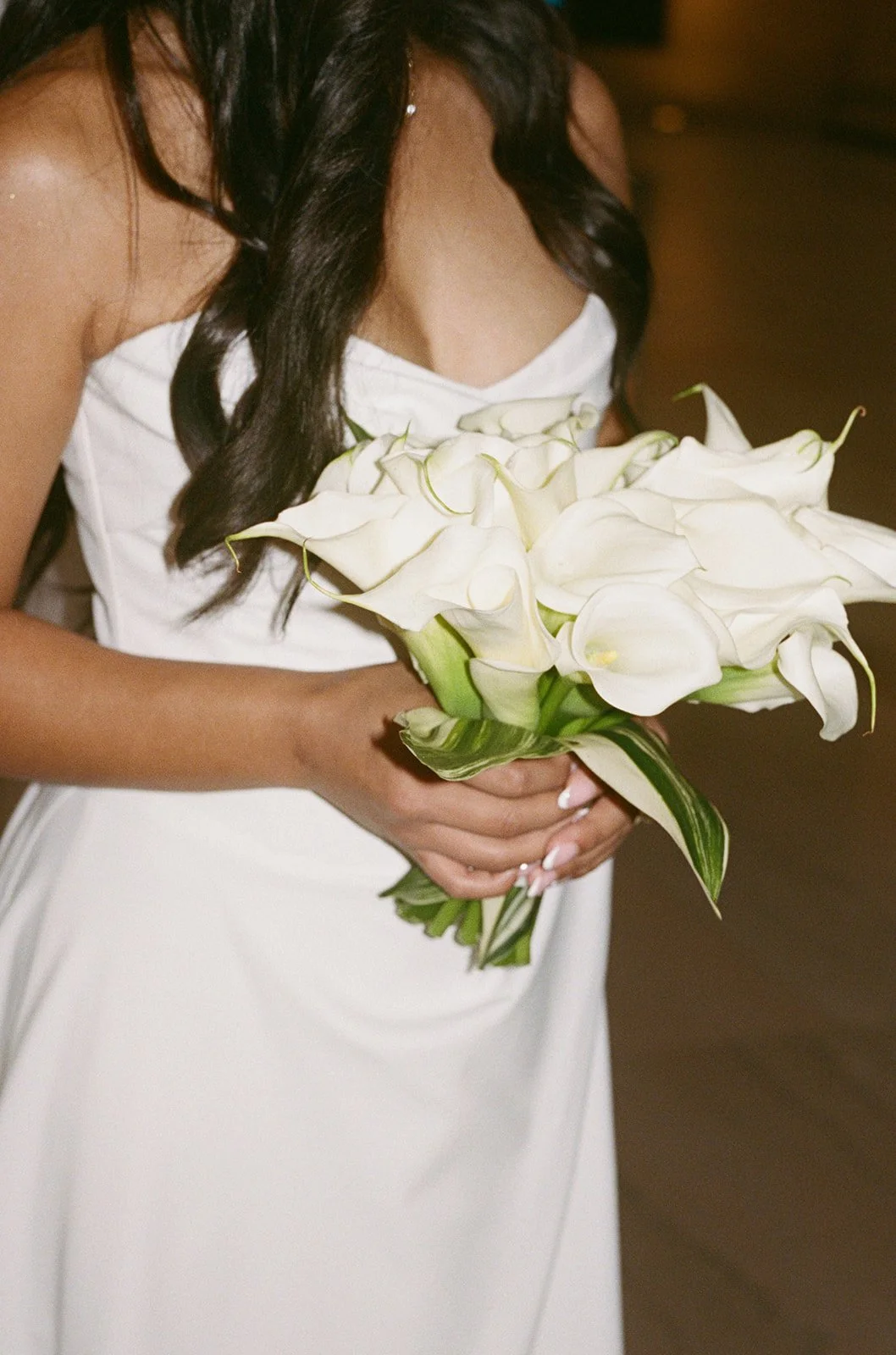 Sarah holding her stunning bouquet of white calla lilies in a studio-lit portrait moment. Shot on film by a Chicago wedding photographer.