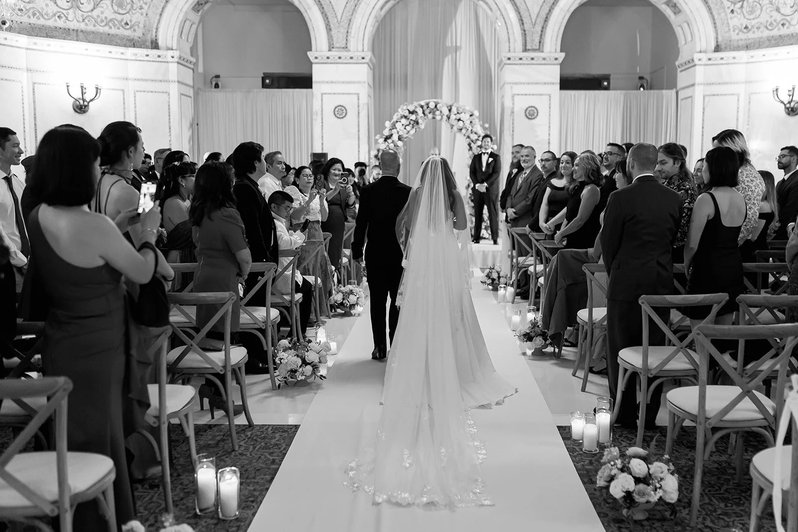 Sarah and her dad walking down the aisle during the processional, from behind