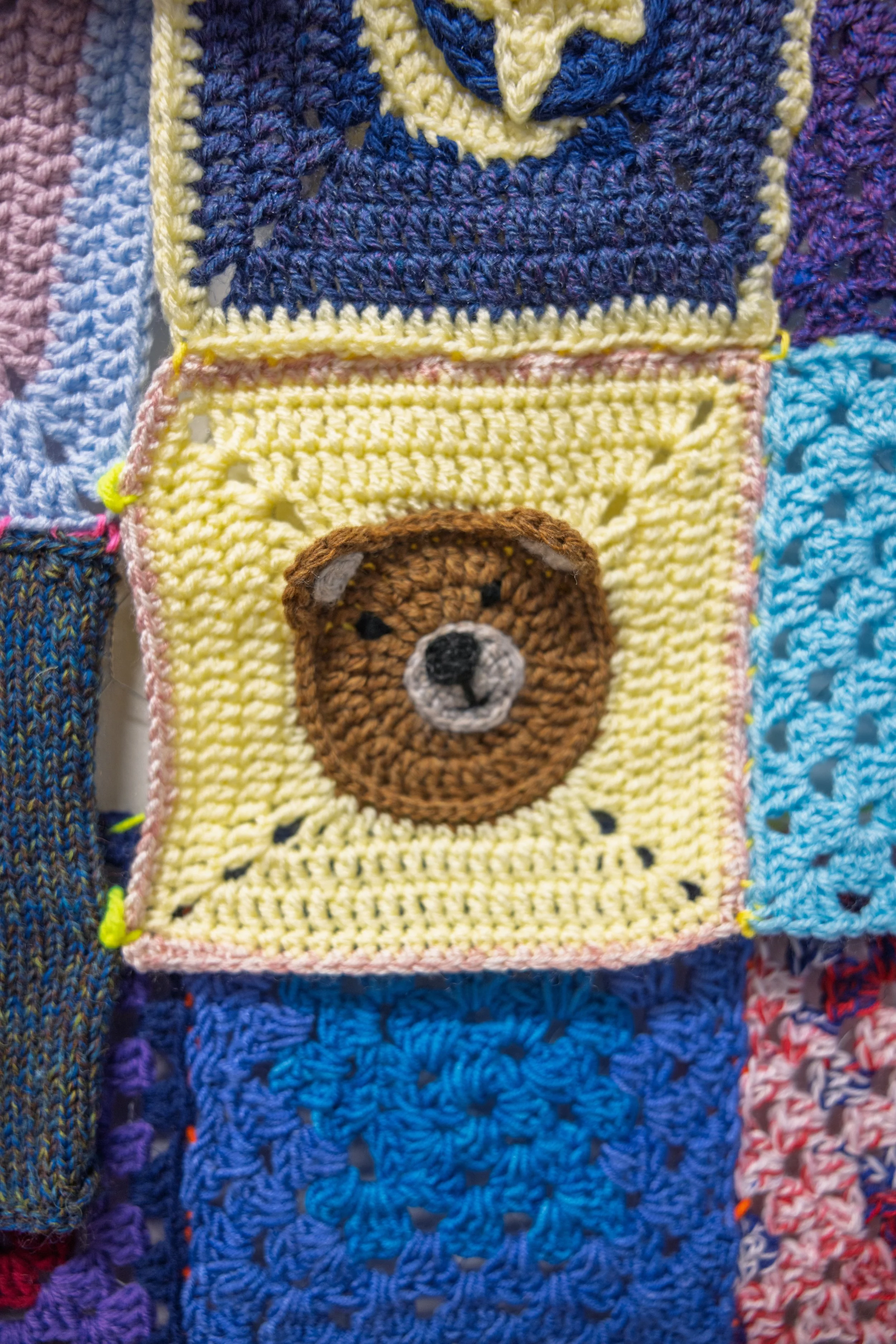 Brown teddy bear face crocheted on yellow square