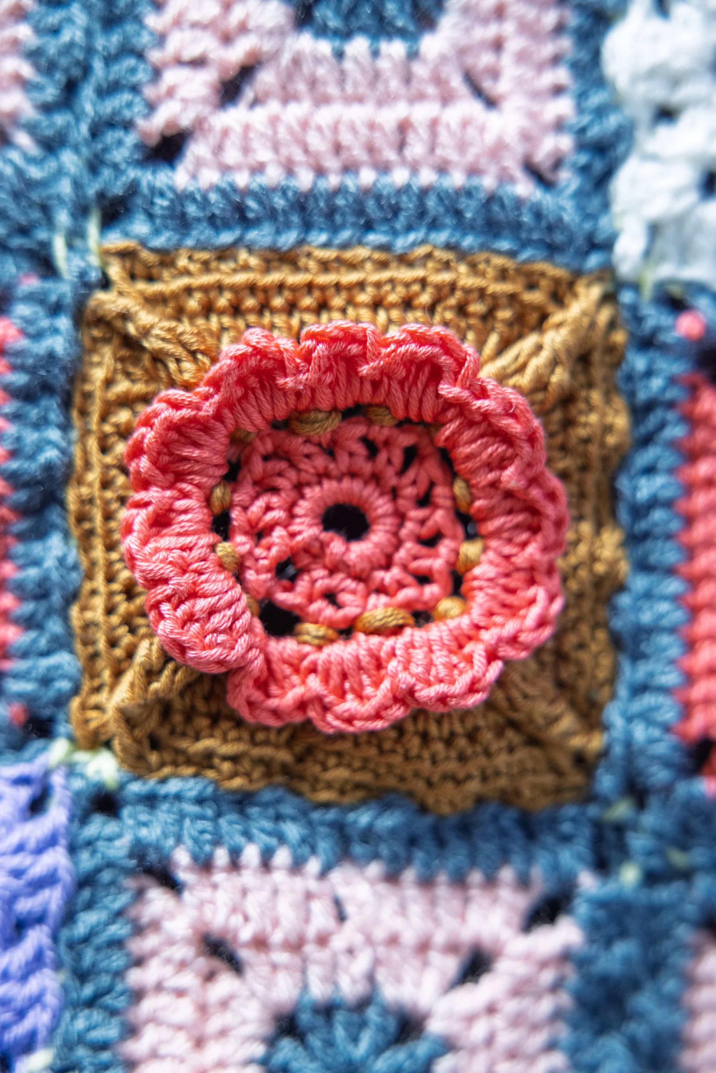 Pink crochet flower on brown background