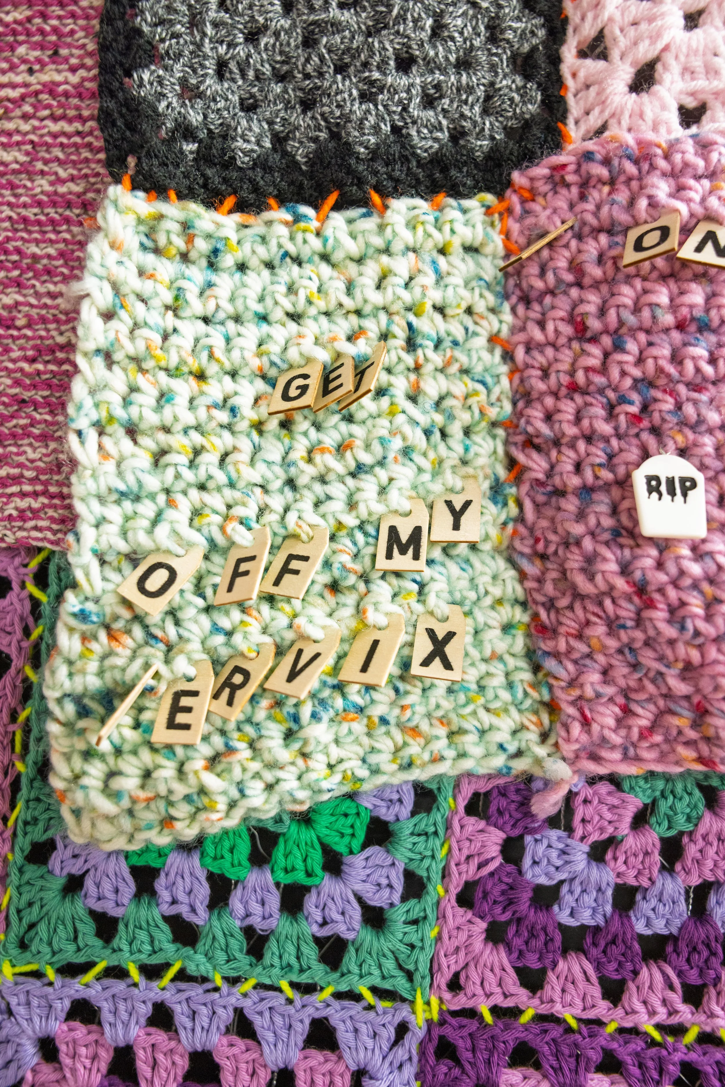 Crocheted square with tabs stating 'Get off my cervix'