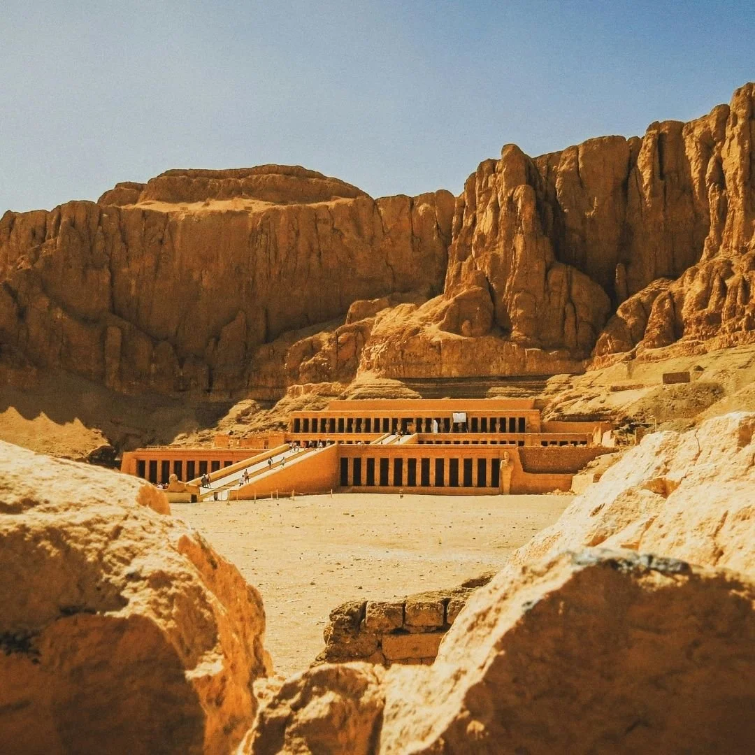 Ancient Egyptian temple set against desert cliffs, viewed in open space that allows the scale and setting to be experienced without crowds.