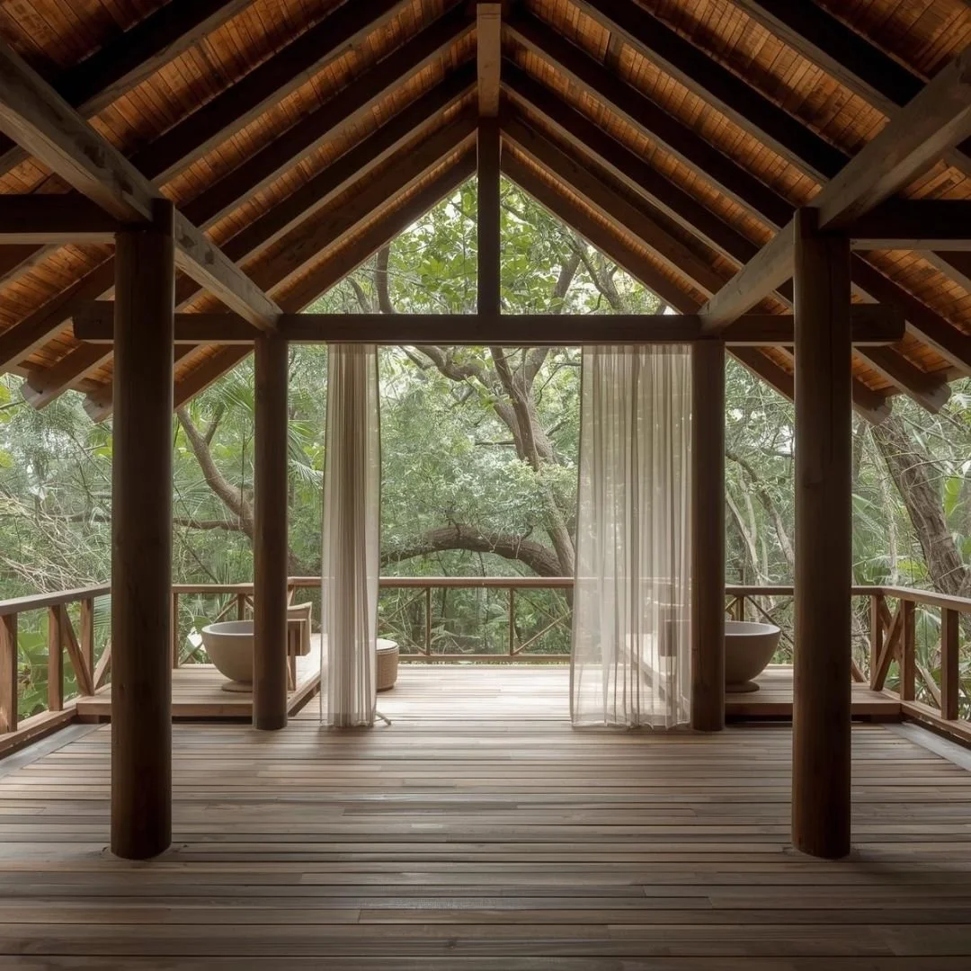 Open-air luxury villa in Bali with a wooden deck, vaulted timber roof, and freestanding soaking tubs overlooking dense tropical forest.