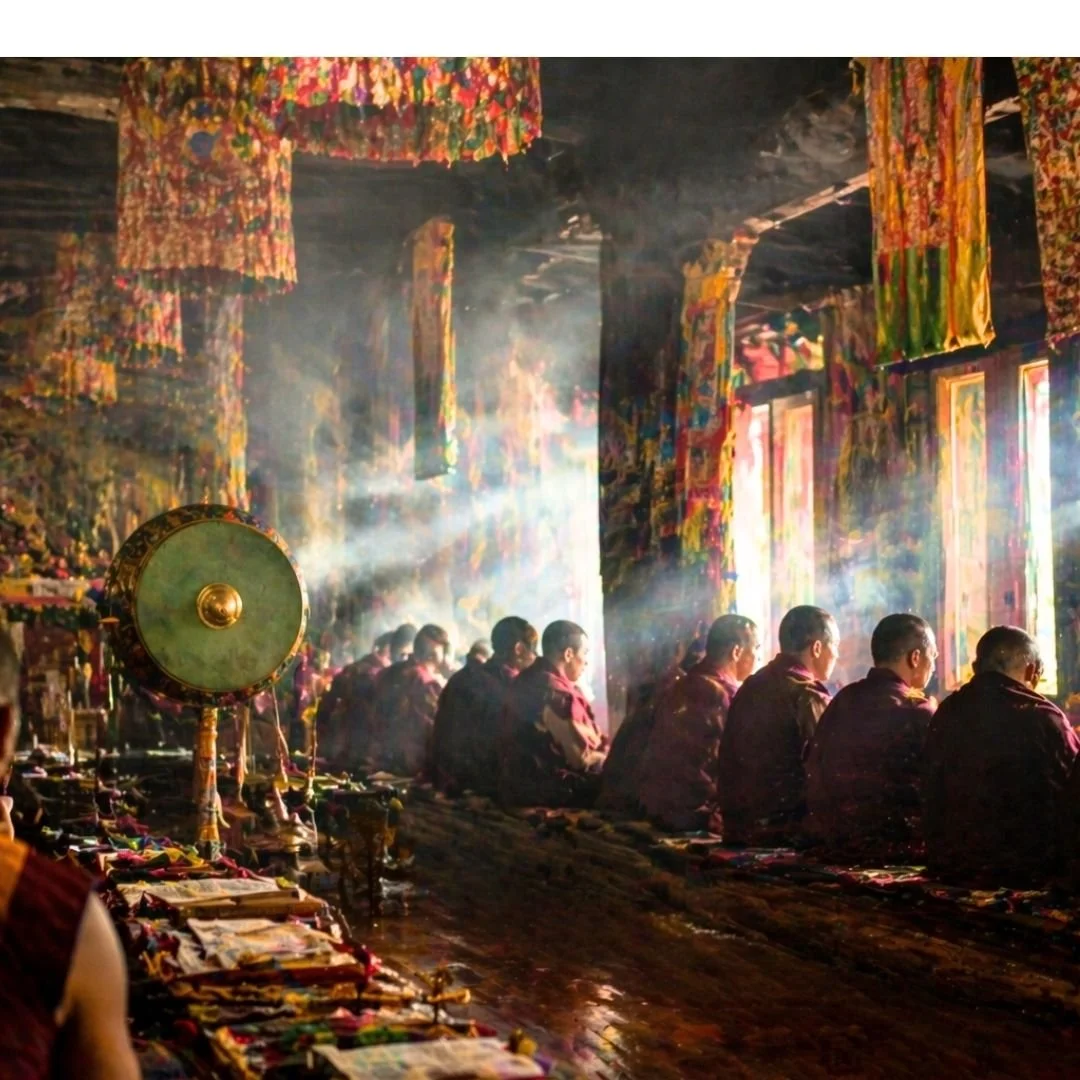 Monks inside Tawang Monastery during early morning prayer with soft natural light and quiet atmosphere