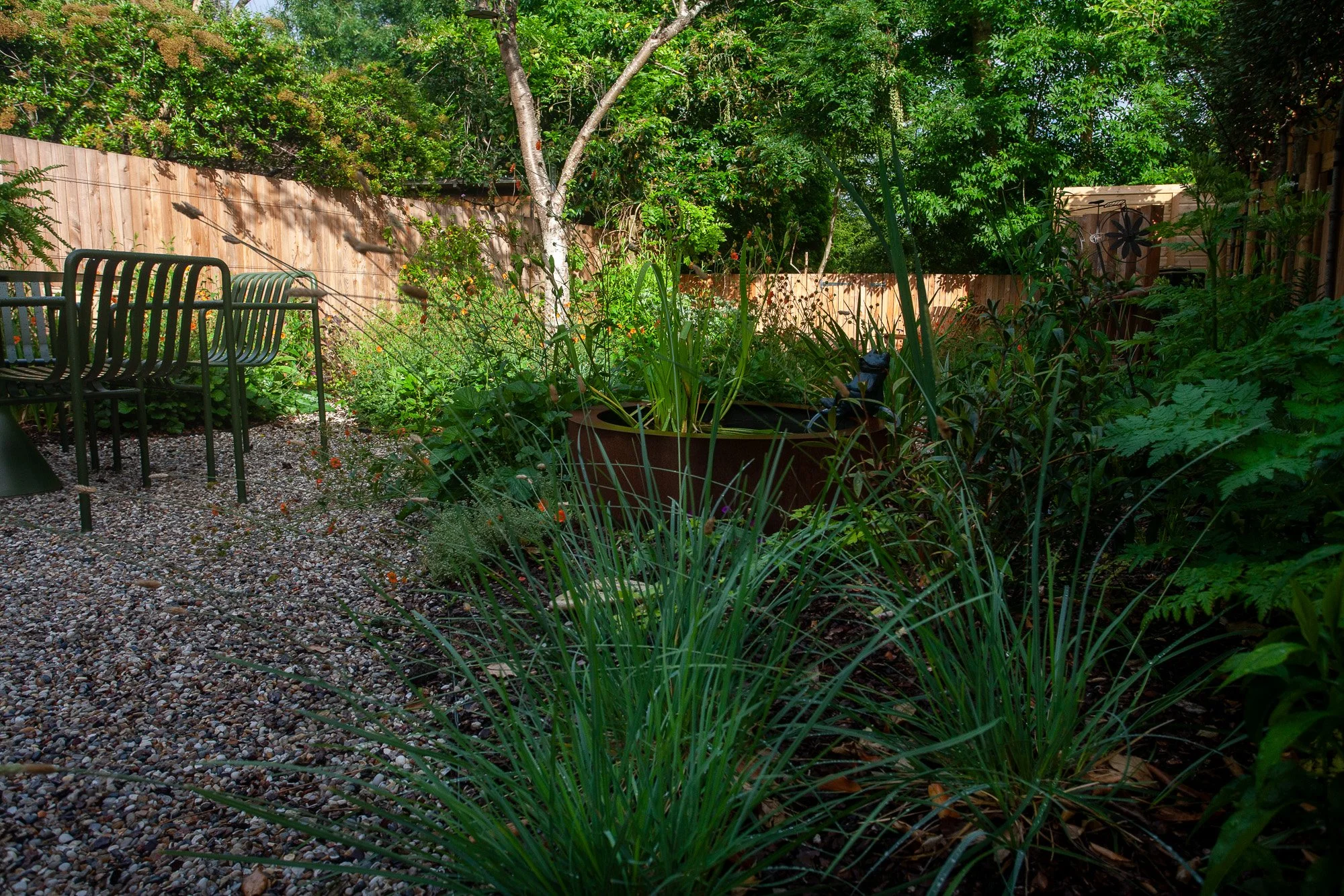 catriona-rowbotham-garden-design-green-chairs-table-gravel-planting-shed..jpg