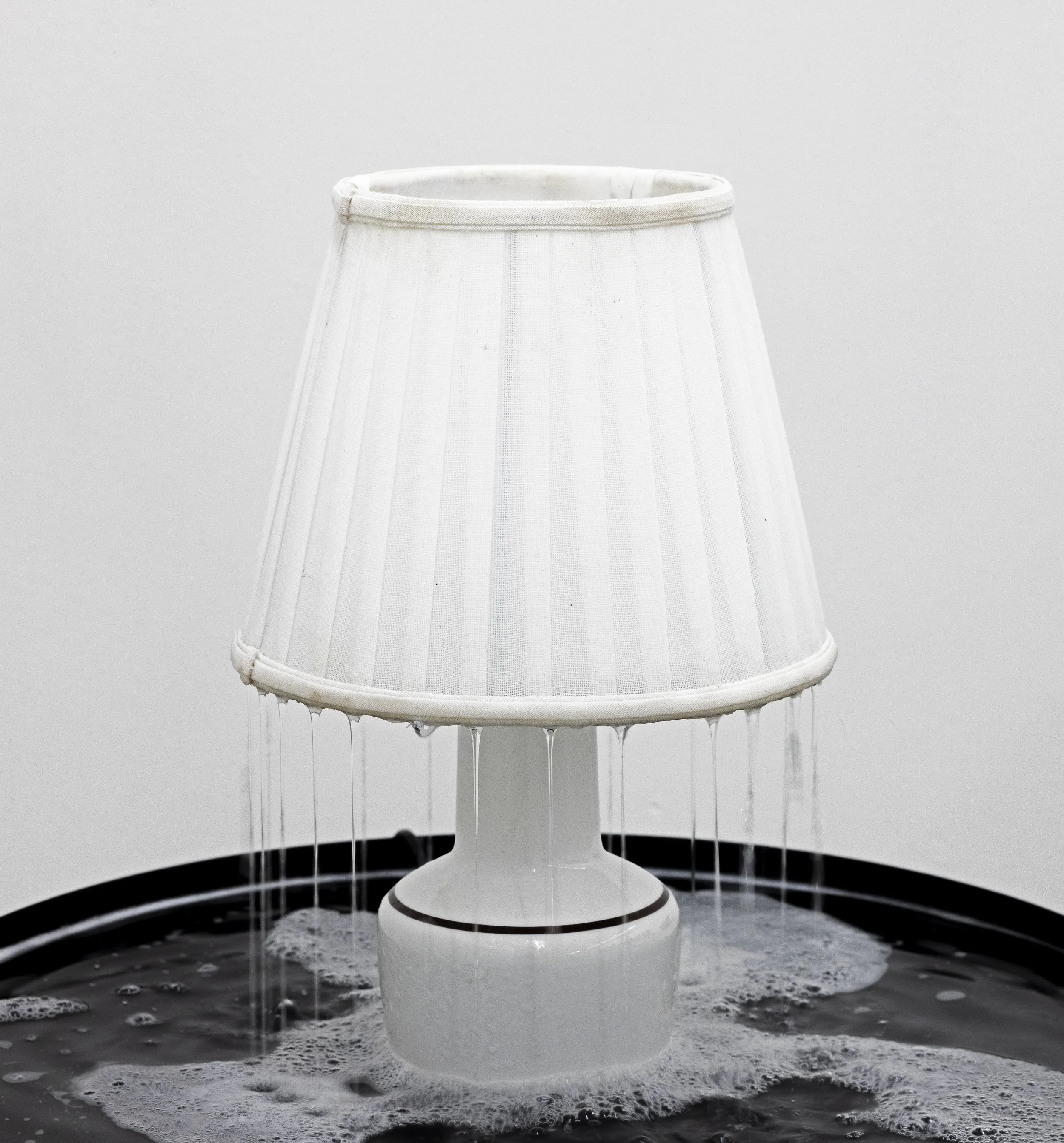 Hjem under tryk (1) / Home Under Pressure (1), detail, 2025. Lamp, water, water pump, table. H: 84,5 cm Ø: 58 cm