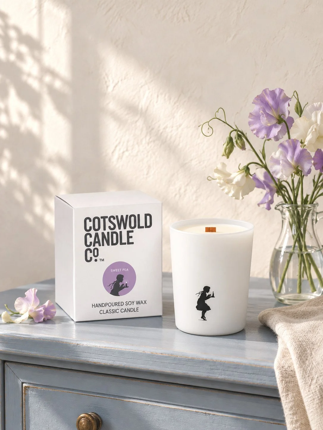 Sweet Pea wood wick candle and matching box by Cotswold Candle Co., styled in a home interior with natural light.