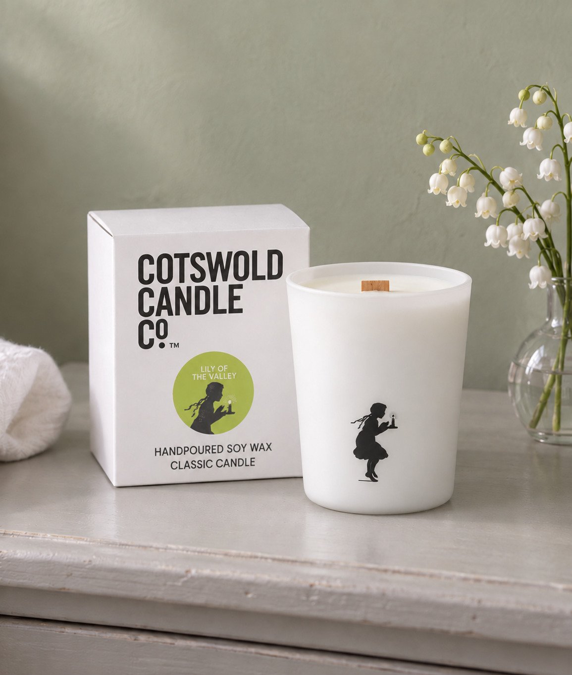 Lily of the Valley wood wick candle and matching box by Cotswold Candle Co., styled in a home interior with natural light.