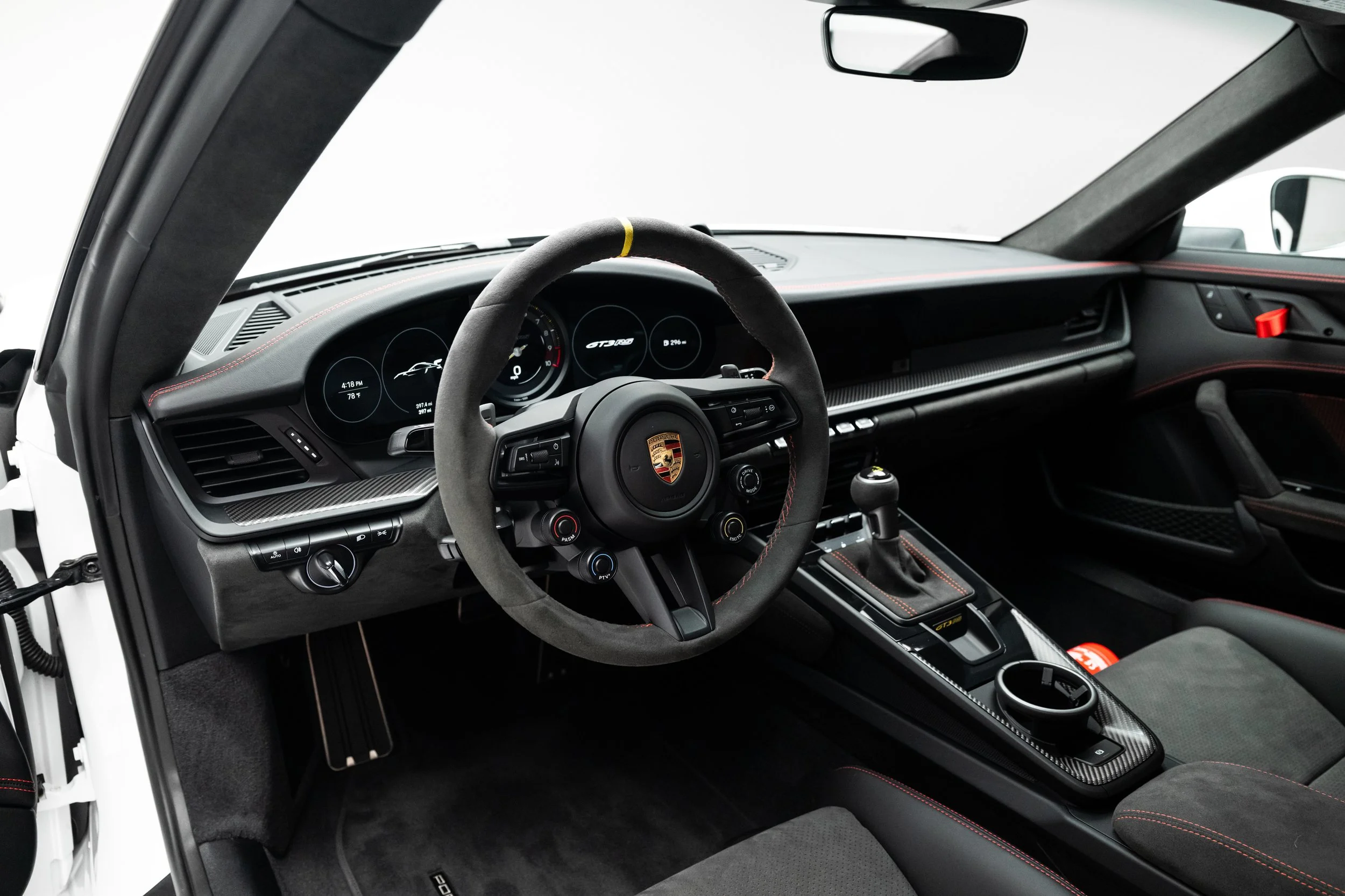 Cockpit view of the 2023 Porsche 911 GT3 RS showing the Race-Tex steering wheel, center tachometer, TFT displays, and Chrono-package dash clock.