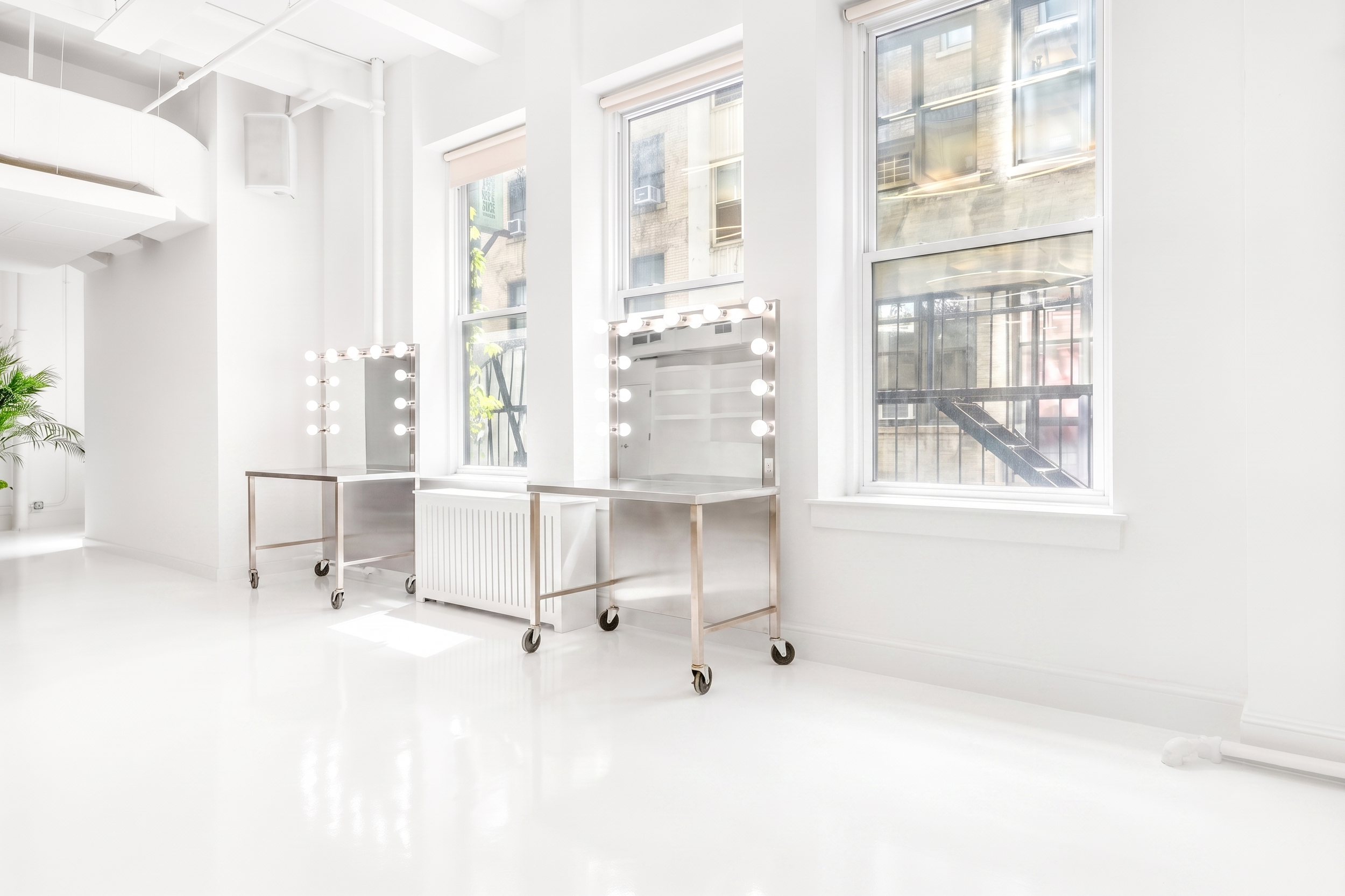 Rolling makeup vanity tables with lighted mirrors in white photo studio