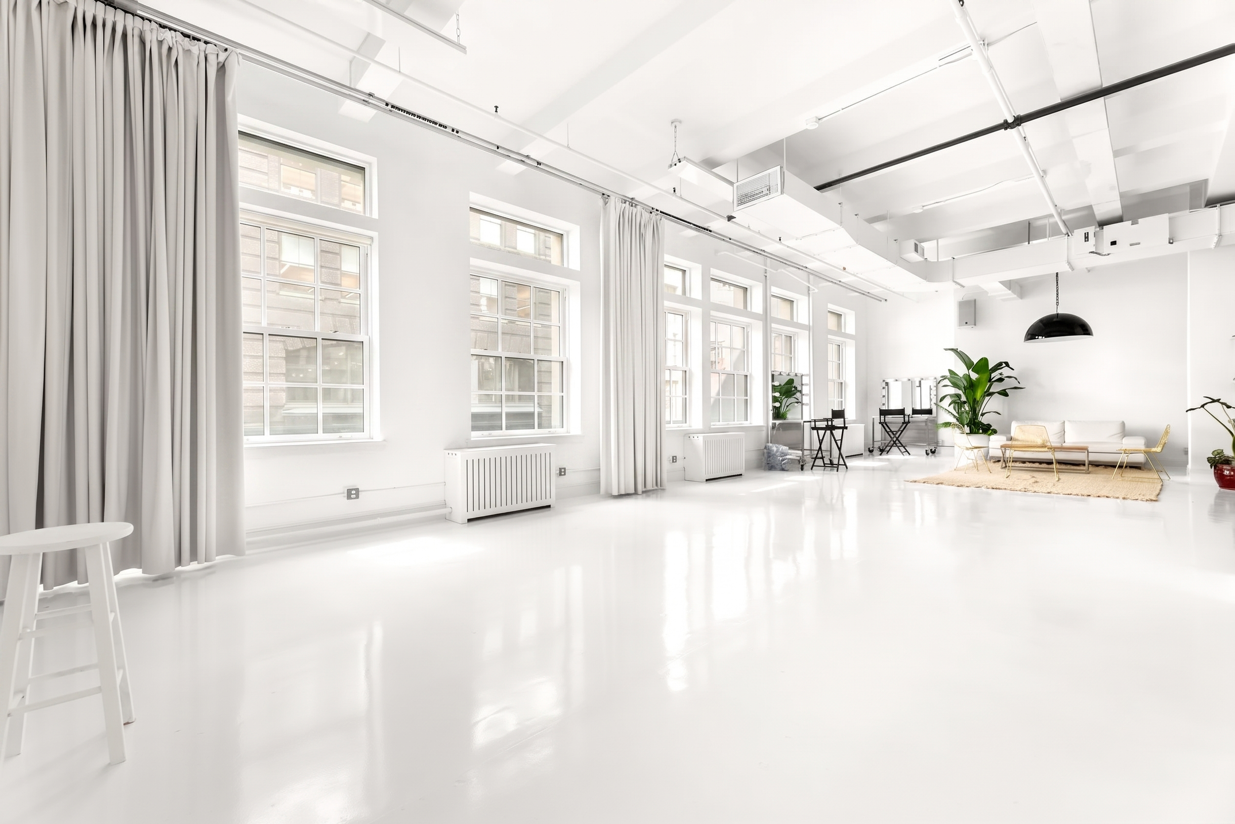 6,000 SF Flatiron Studio NYC, 50 W 17th Street, large windows, natural daylight, white epoxy floors, blackout drapes, lounge area, 14' ceiling, fashion and editorial photo studio rental Flatiron District New York.
