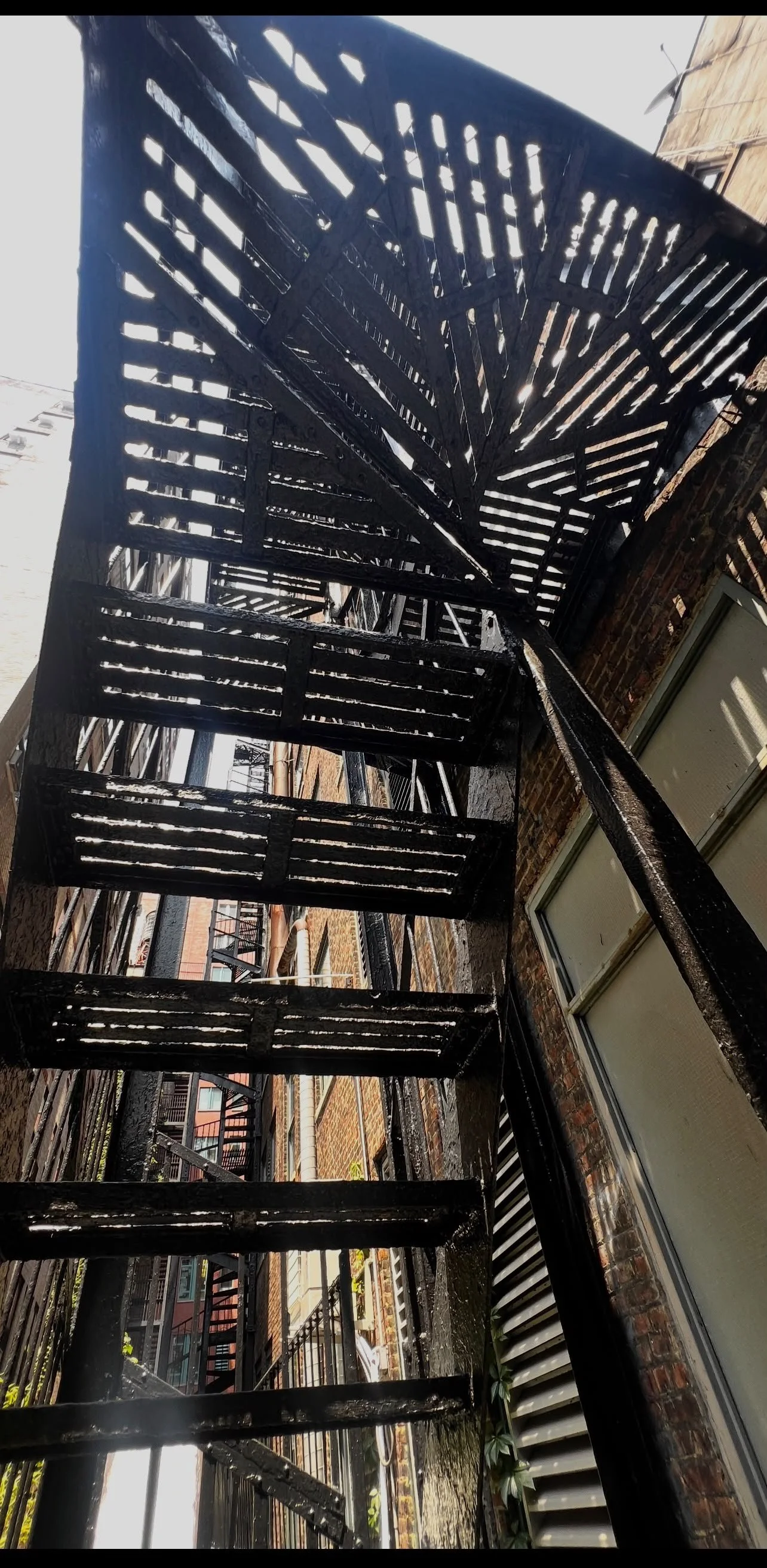 Upward view of spiral iron staircase, loft fire escape architecture