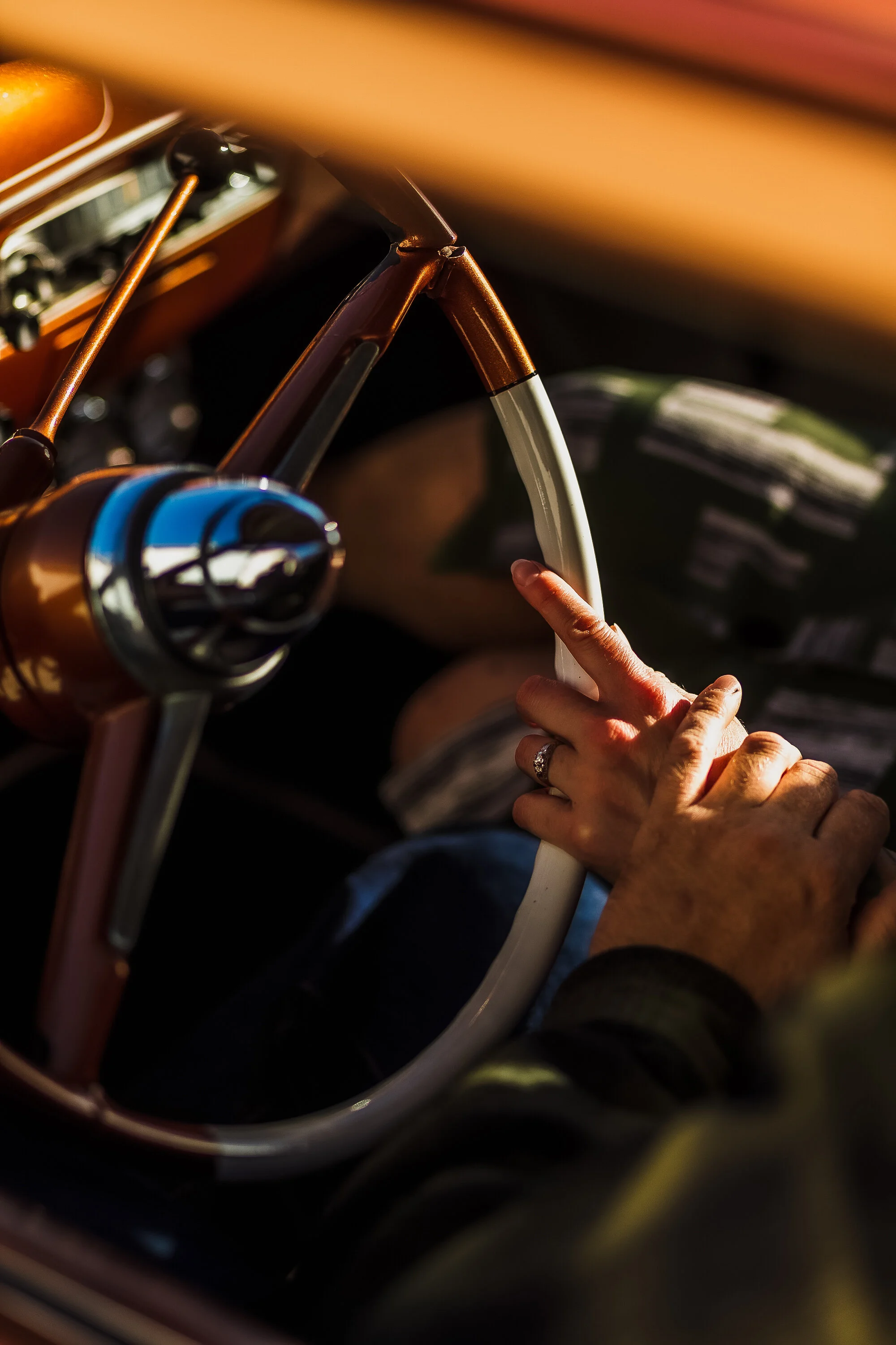 Close-up of an engagement ring and hands on the steering wheel of a restored 1953 Ford hot rod during a Napa Valley engagement photo session.
