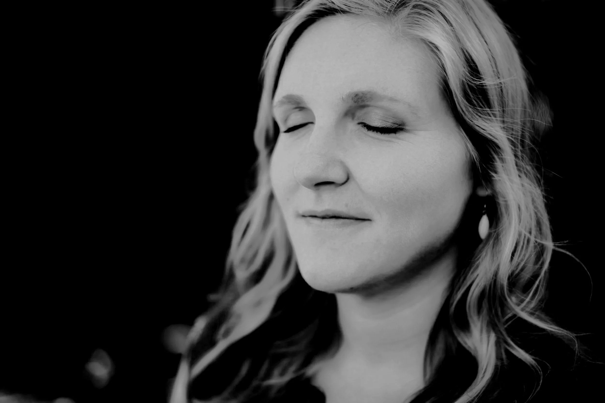 Peaceful woman smiling thoughtfully during a 4-week divorce support group and life coaching series for women starting a new chapter.