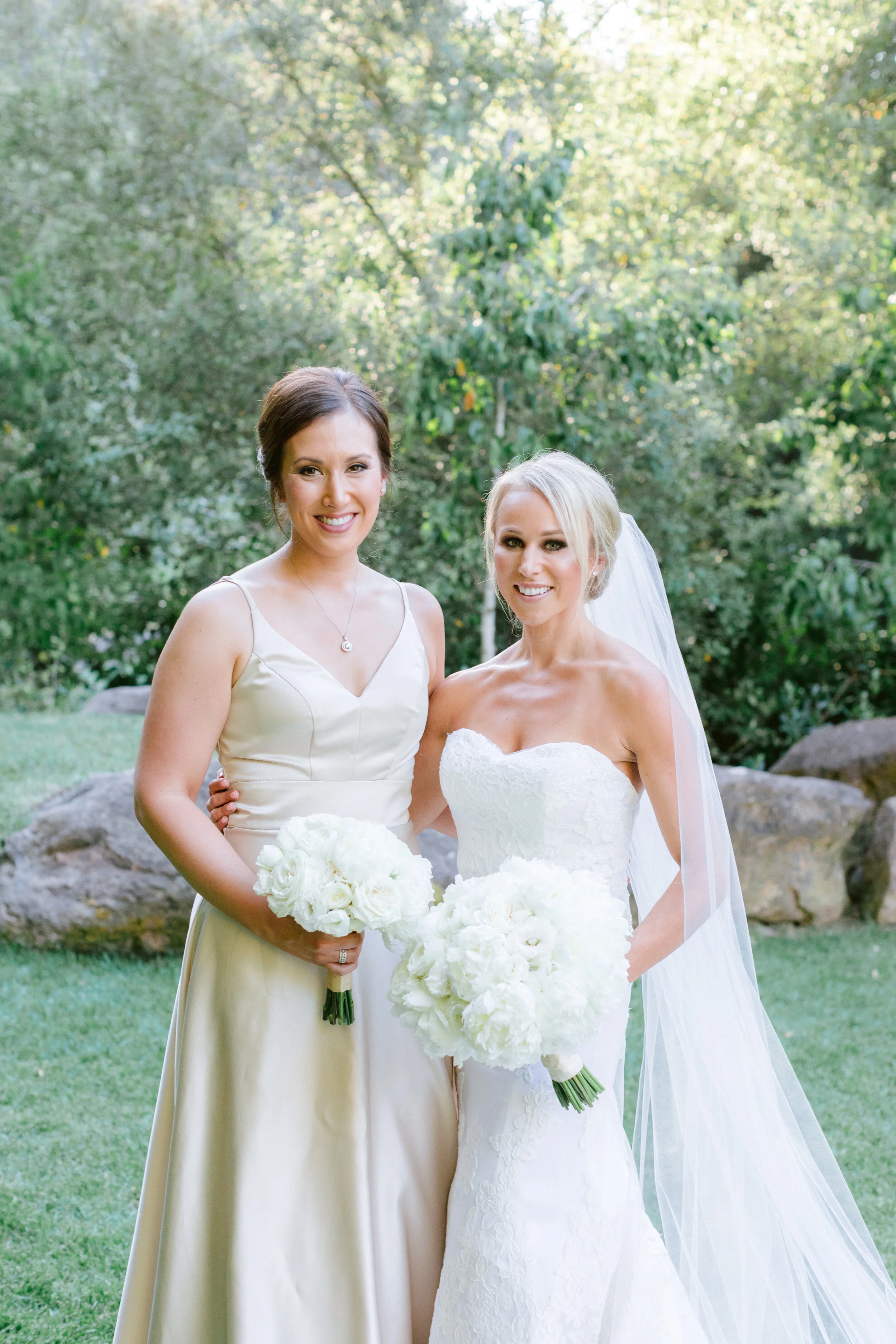 Bride and bridesmaid hold bouquets of white roses white peonies white hydrangeas image name: wedding-florist-boise-645