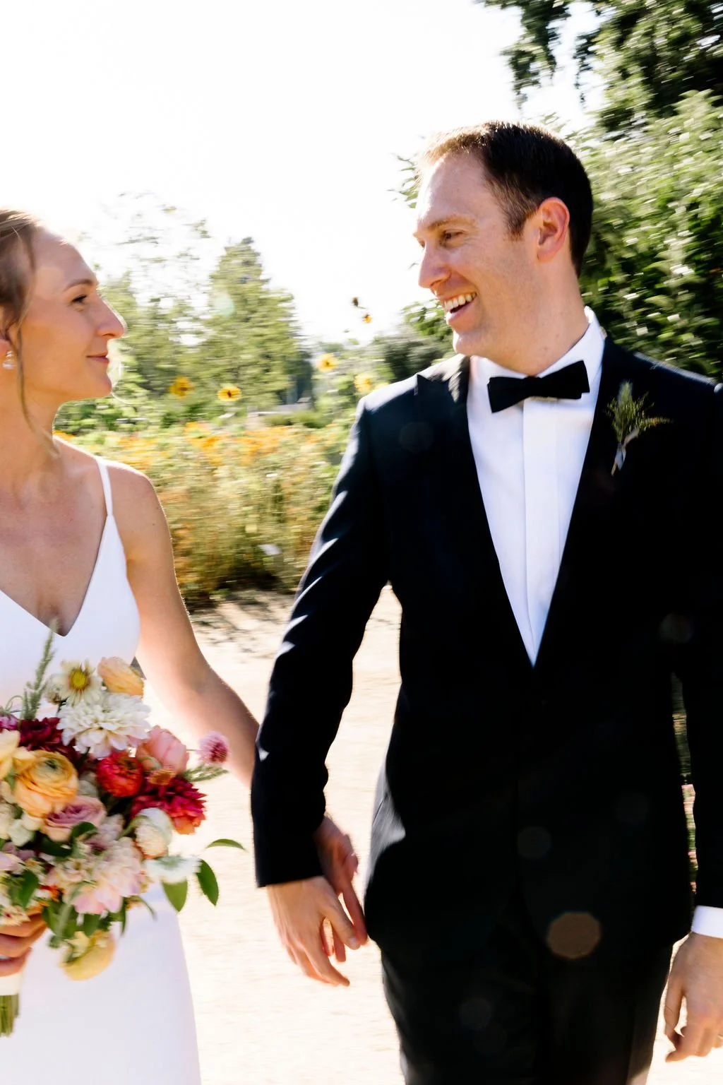 Bride holding bouquet pink dahlias, white dahlias peach ranunculus San Francisco California . Image name: wedding-florist-boise-90