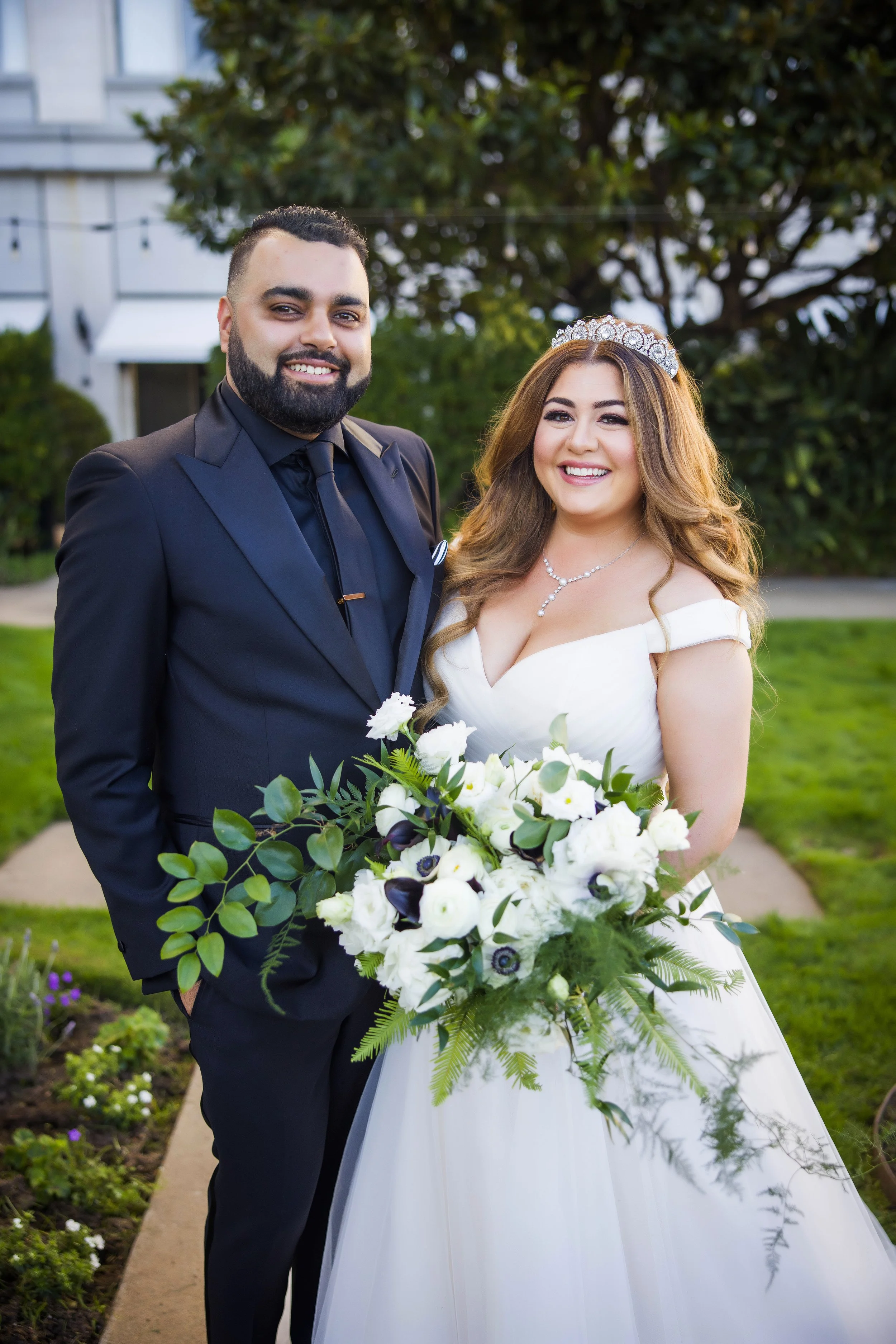 Couple stands with bouquet of with white roses white anemone ferns image name: wedding-florist-boise-381
