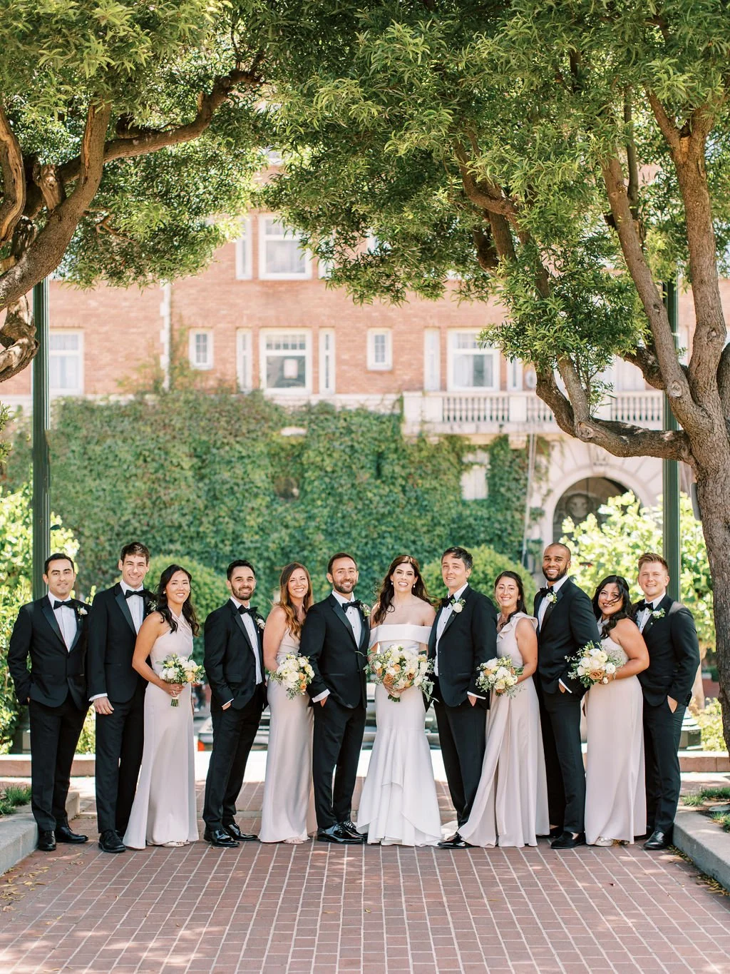 Bridal party holds bouquets of white roses, yellow roses, pink roses. Image name: wedding-florist-129