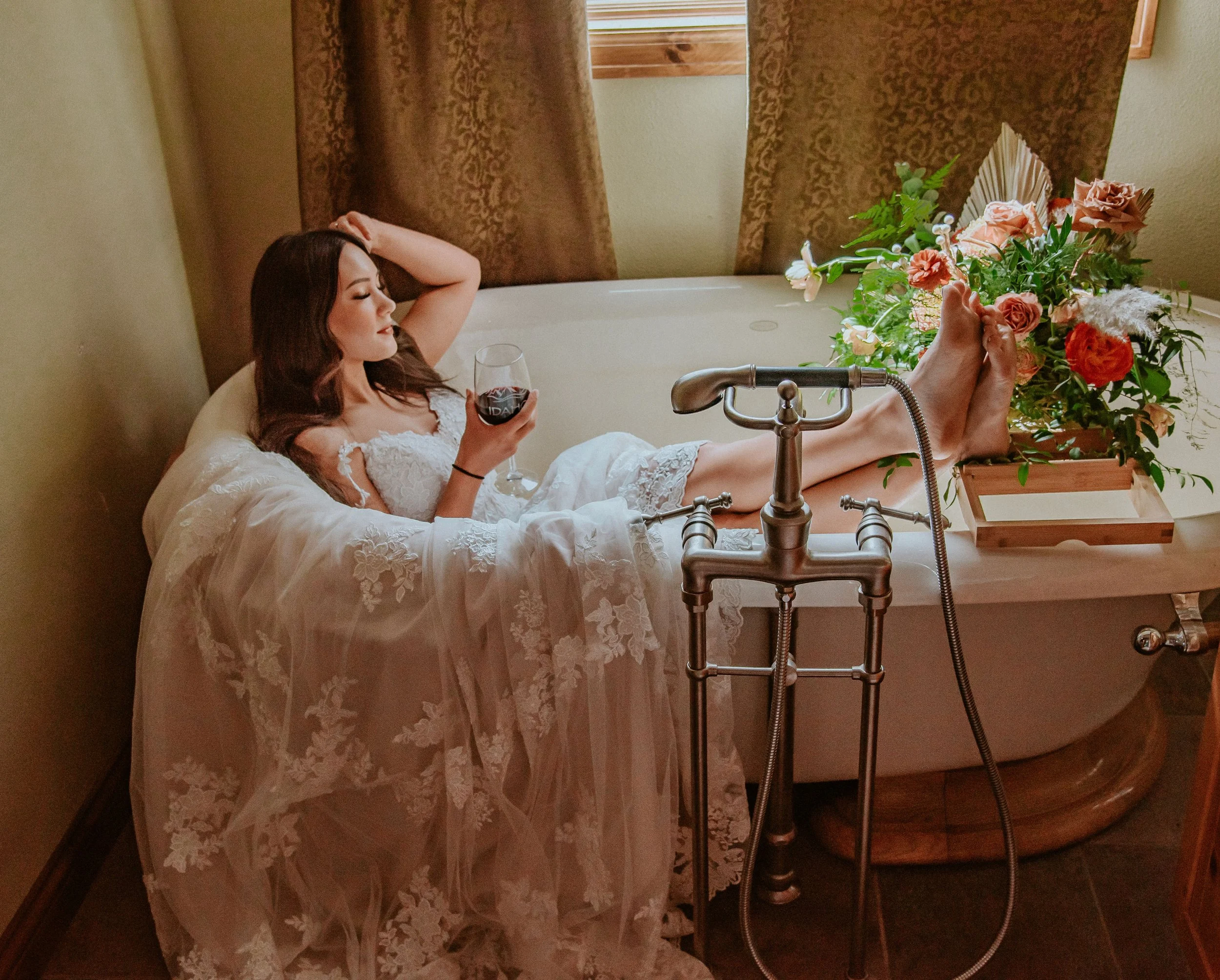 Bride sits bathtub wedding bouquet roses, ranunculus, wildflowers. Image name: wedding-florist-boise-118