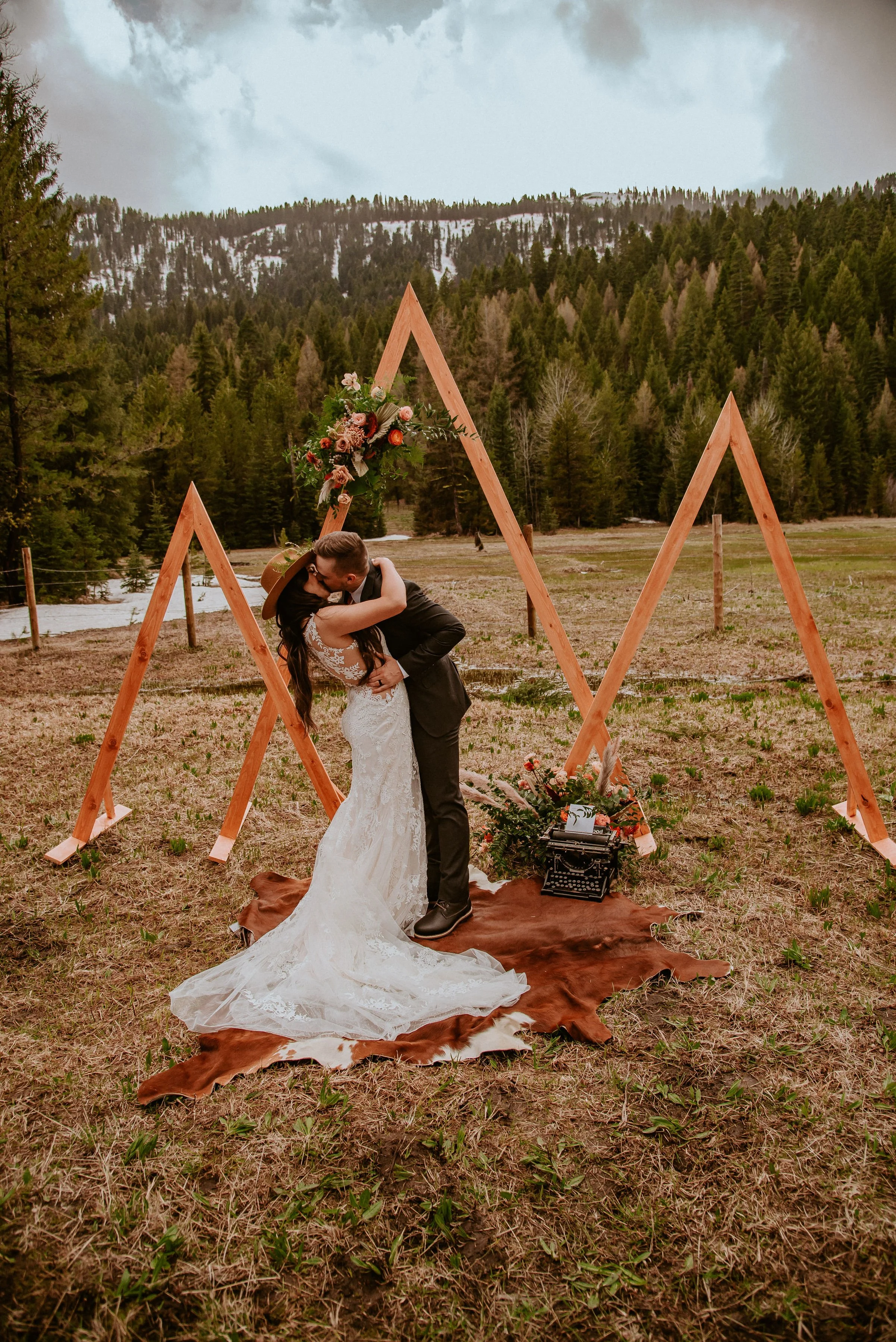 Couple kissing spray rustic color flowers  roses ranunculus. Image name: wedding-florist-boise-105