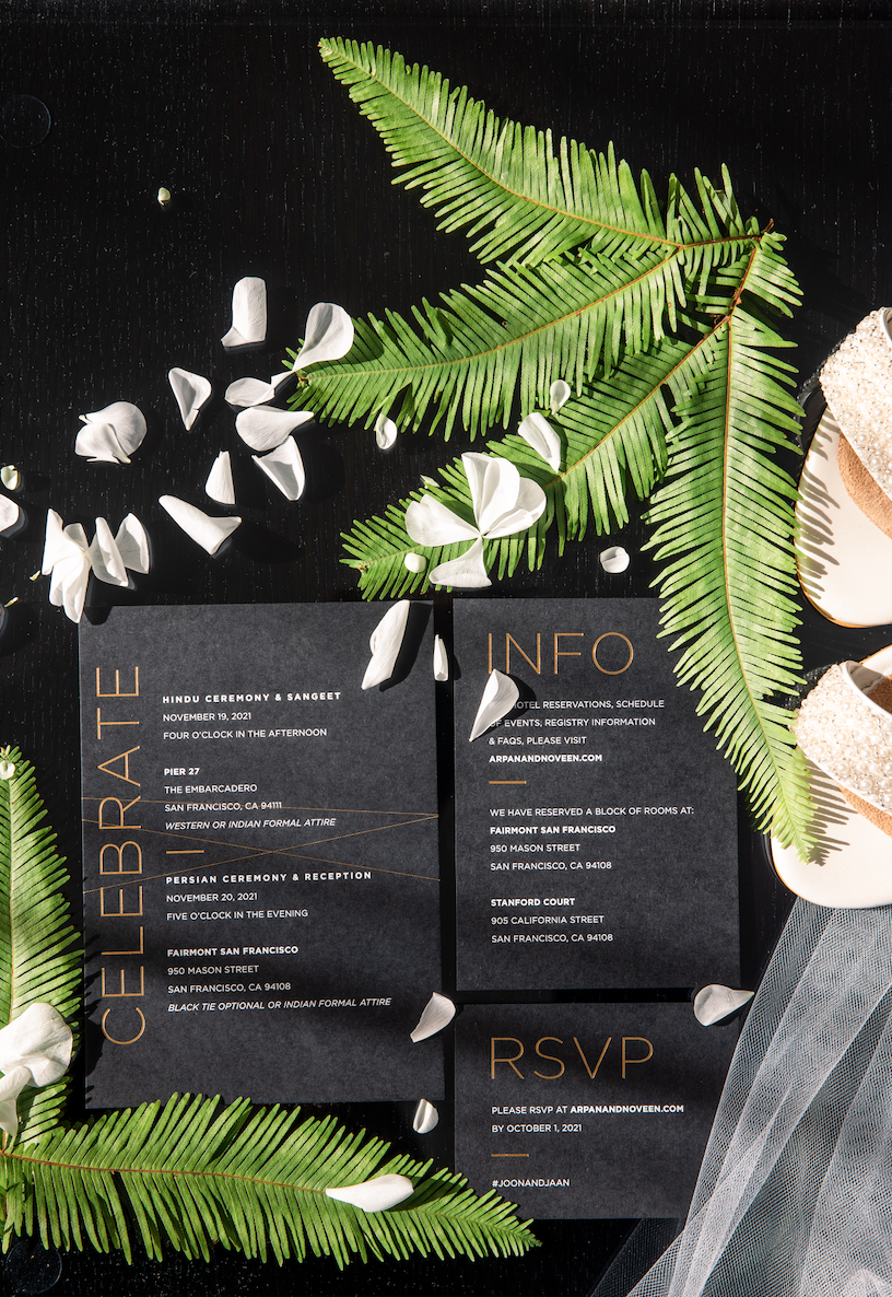Green ferns white petals next to modern black wedding invitations image name: wedding-florist-boise-389