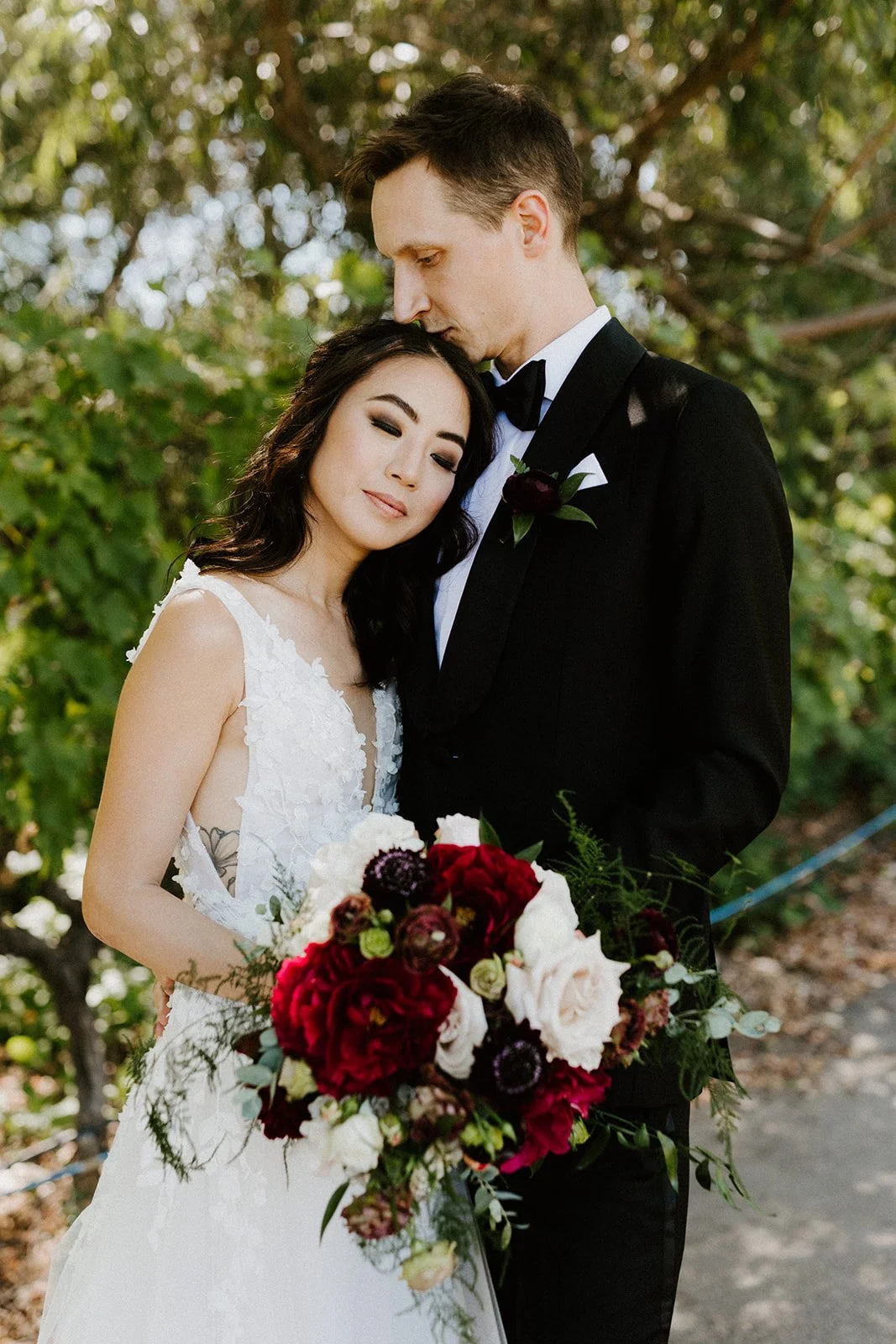 Couple standing holding bouquet burgundy roses white roses image name: wedding-florist-boise-195