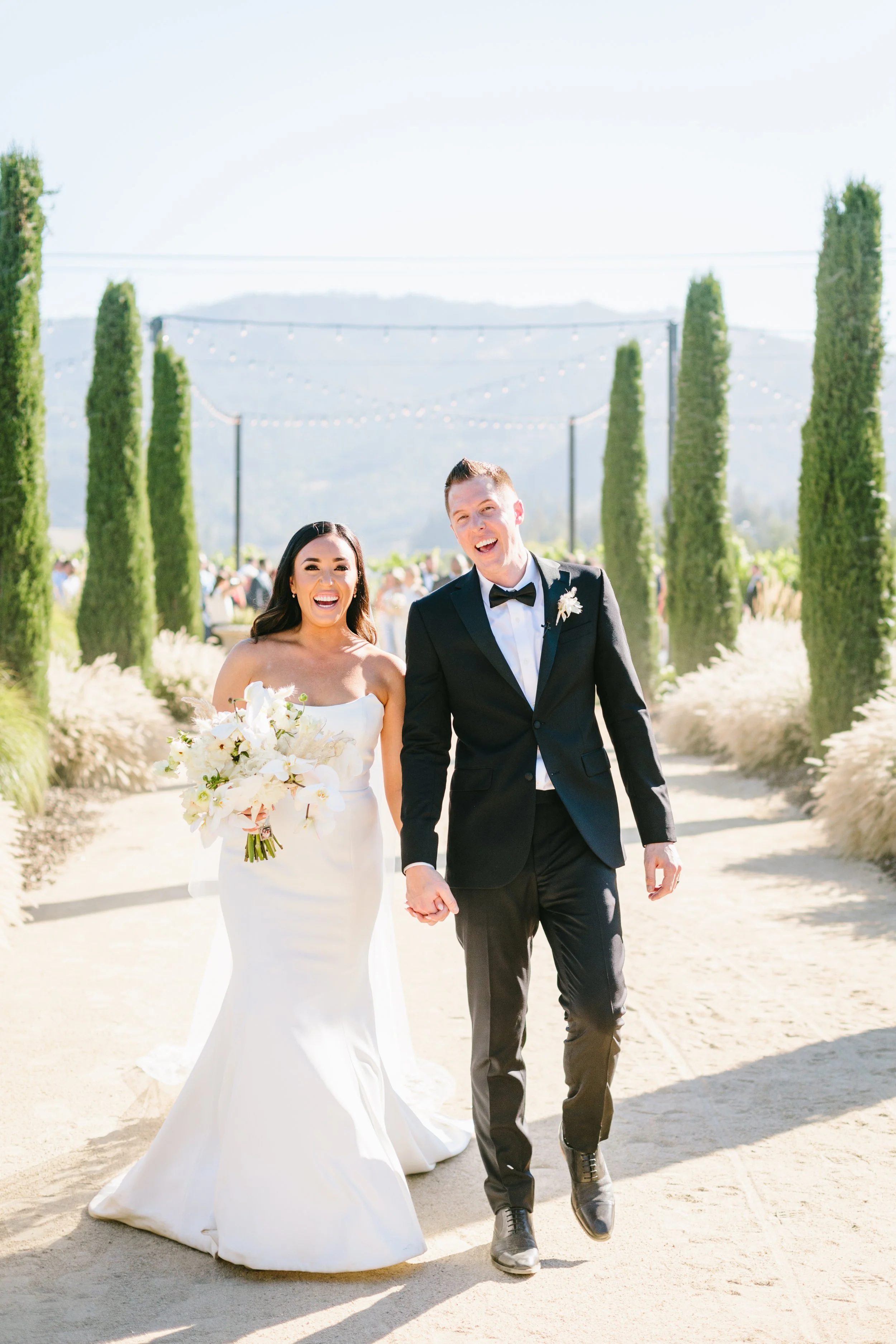 Bride holds bouquet of wild white roses, white orchids, white hydrangeas. Image name: wedding-florist-boise-162
