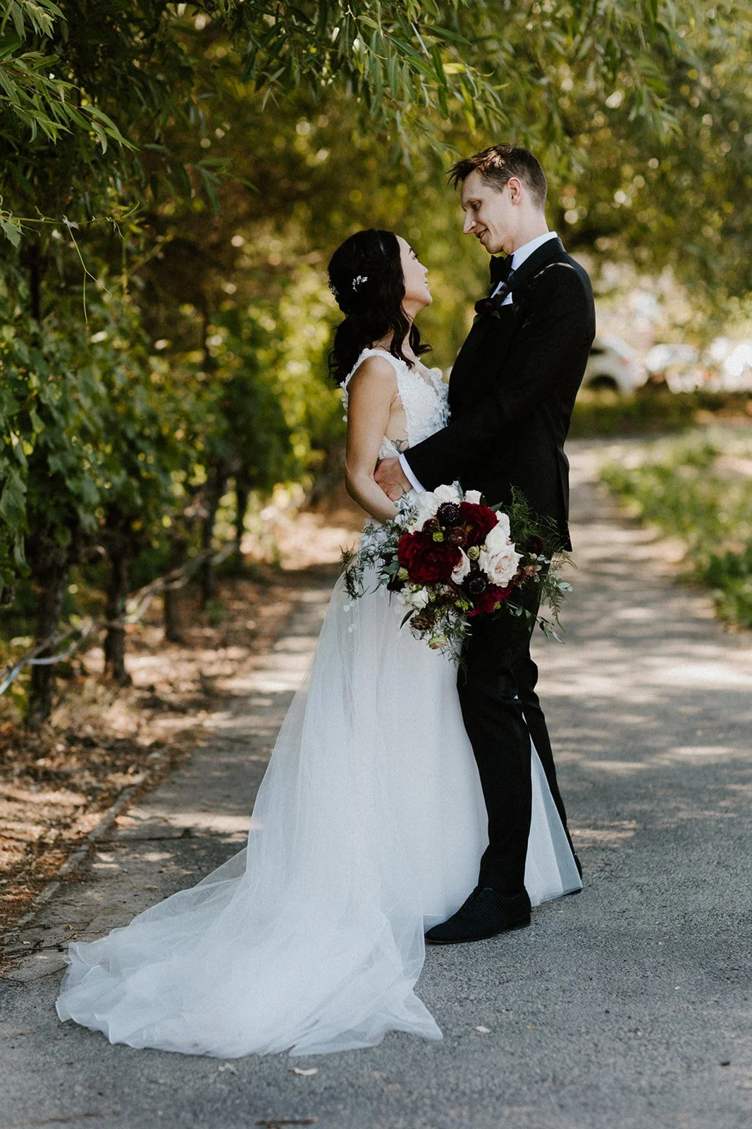 Couple together under tree with autumn color bouquet image name: wedding-florist-boise-194