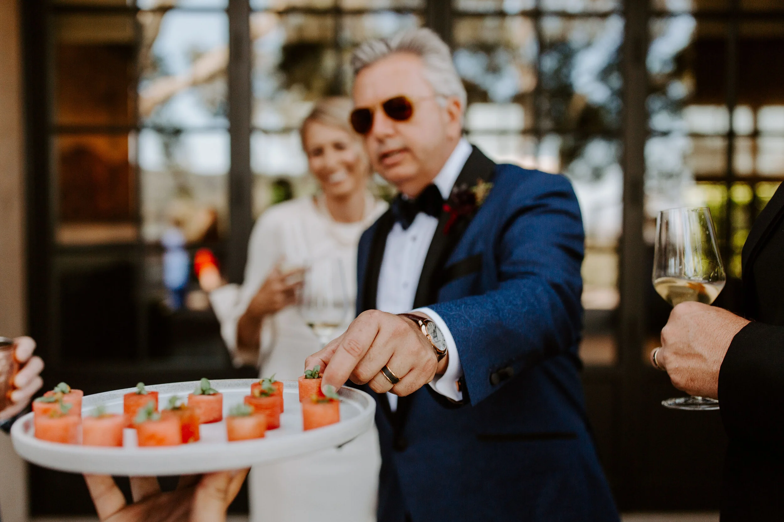 Groom reaches for hors devours at Promontory Wine Estate wedding image name: wedding-florist-boise-553