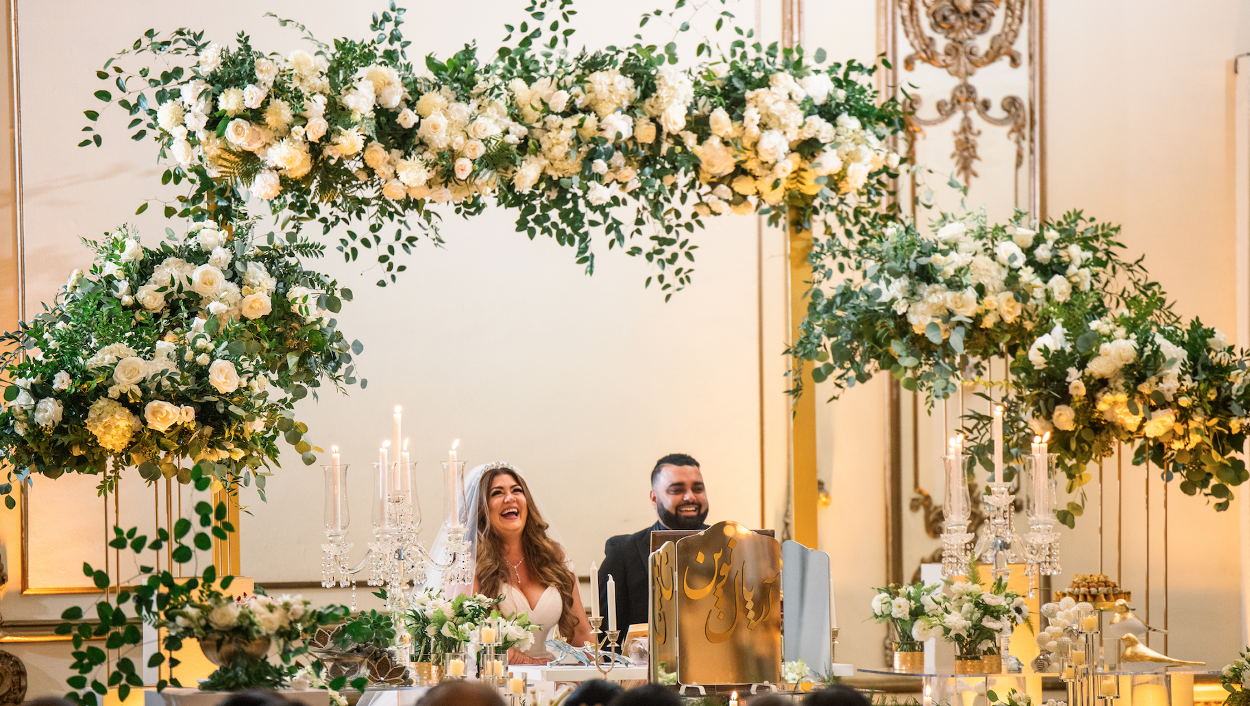 Couple sits under an arch of white roses in San Francisco, CA image name: wedding-florist-boise-391