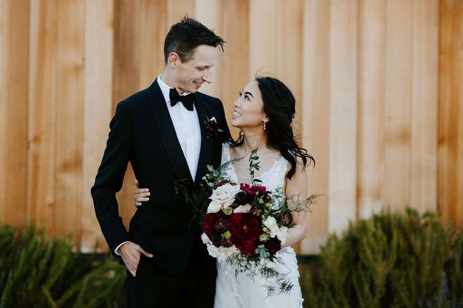 Wedding couple holding burgundy  roses white roses blush roses image name: wedding-florist-boise-219