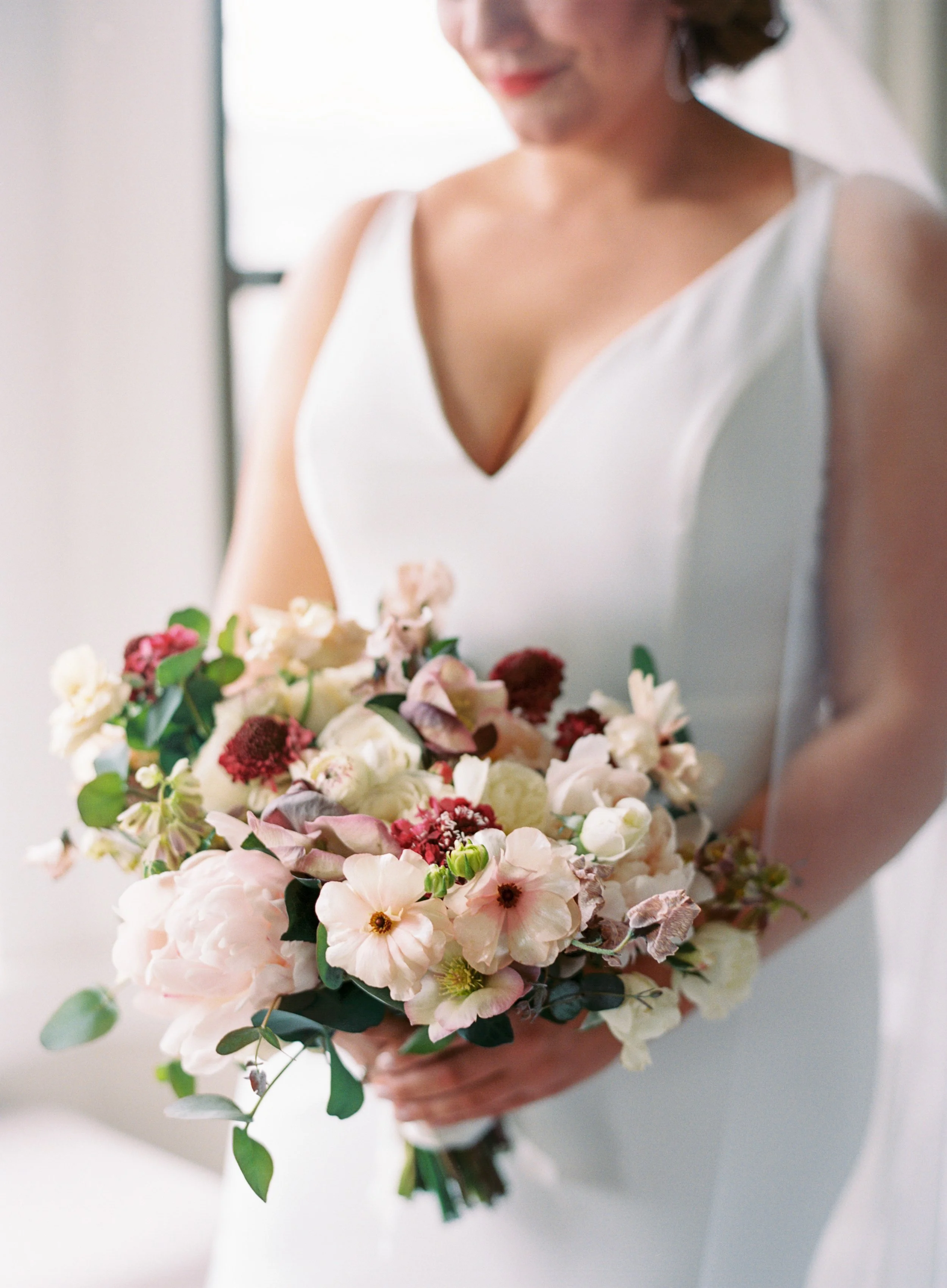 Bride holding bouquet of anemone, peonies, white roses image name: wedding-florist-boise-397