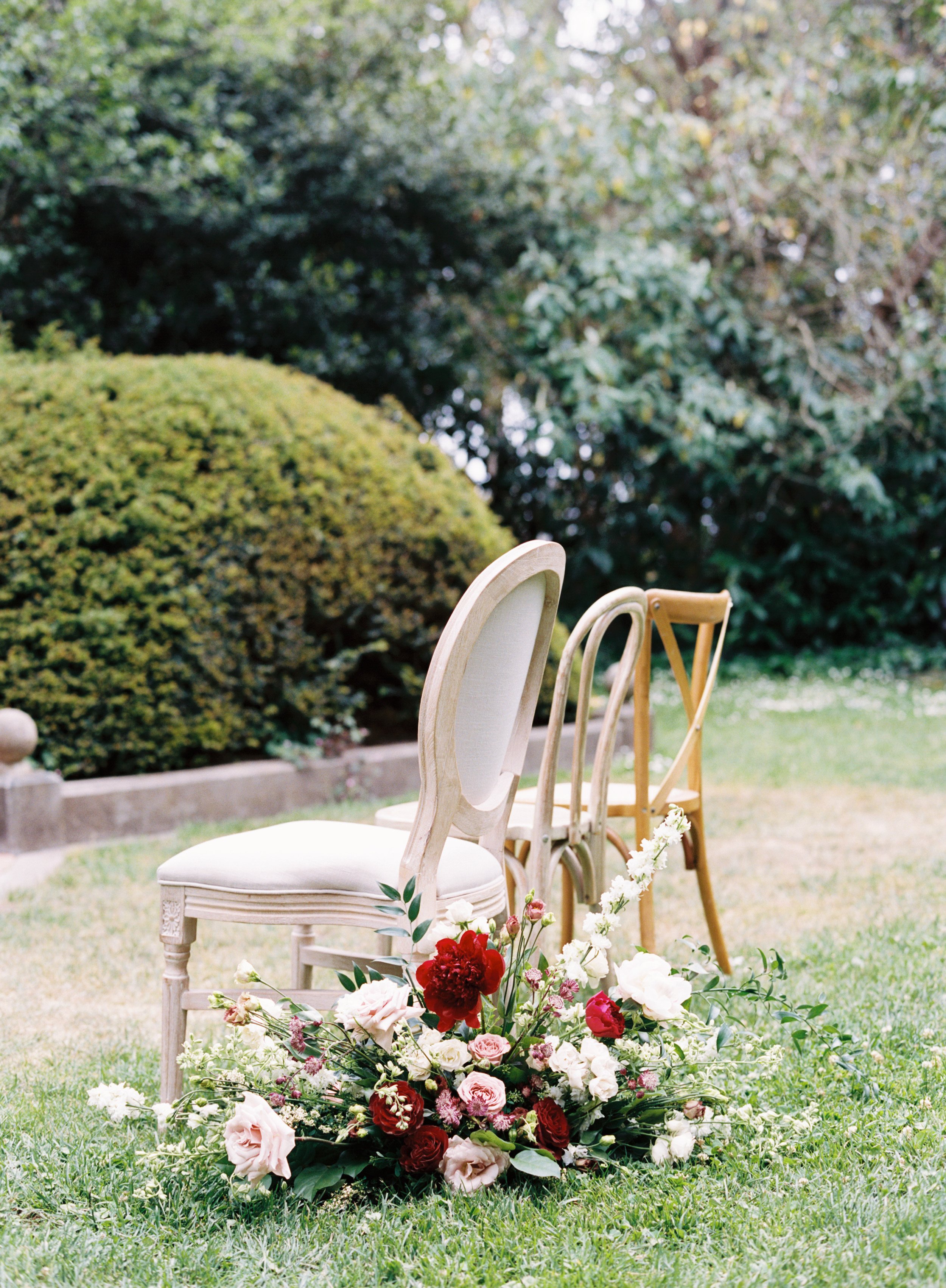 Two chairs next to red peonies red roses white roses pink roses image name: wedding-florist-boise-407