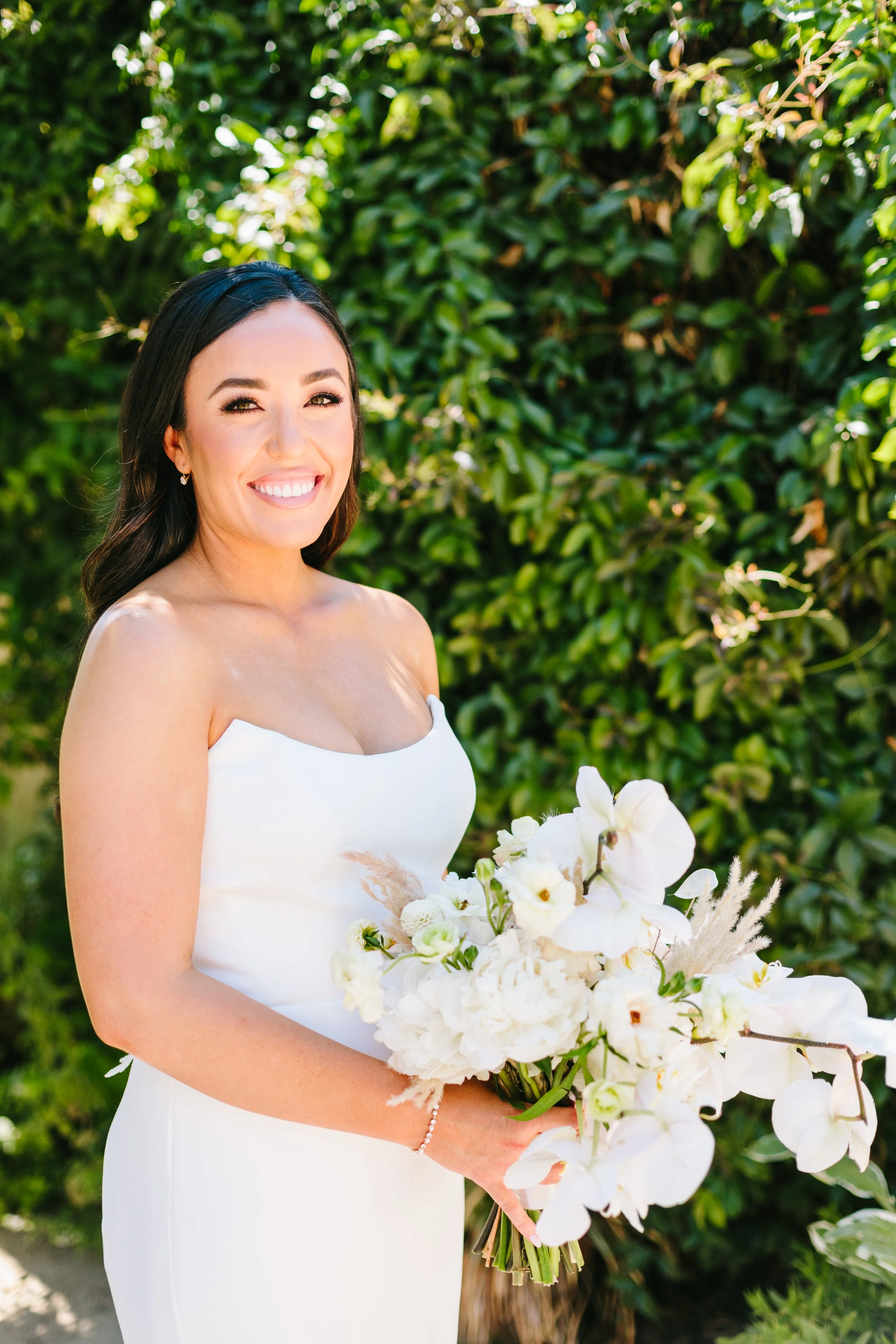 Bride holds bouquet wild white roses, white orchids, white hydrangeas. Image name: wedding-florist-boise-151