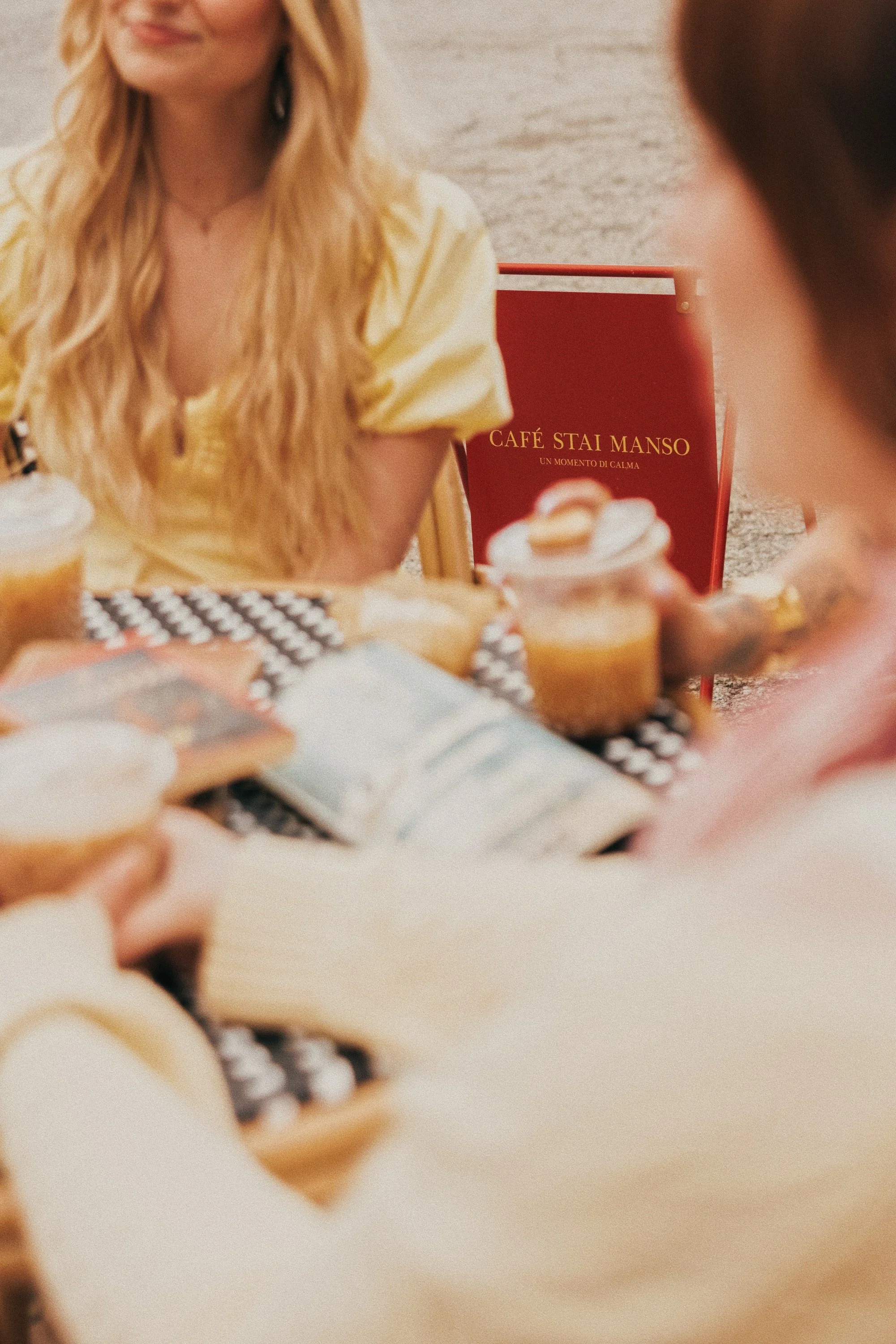People sitting around a table with drinks and desserts at Café Stai Manso