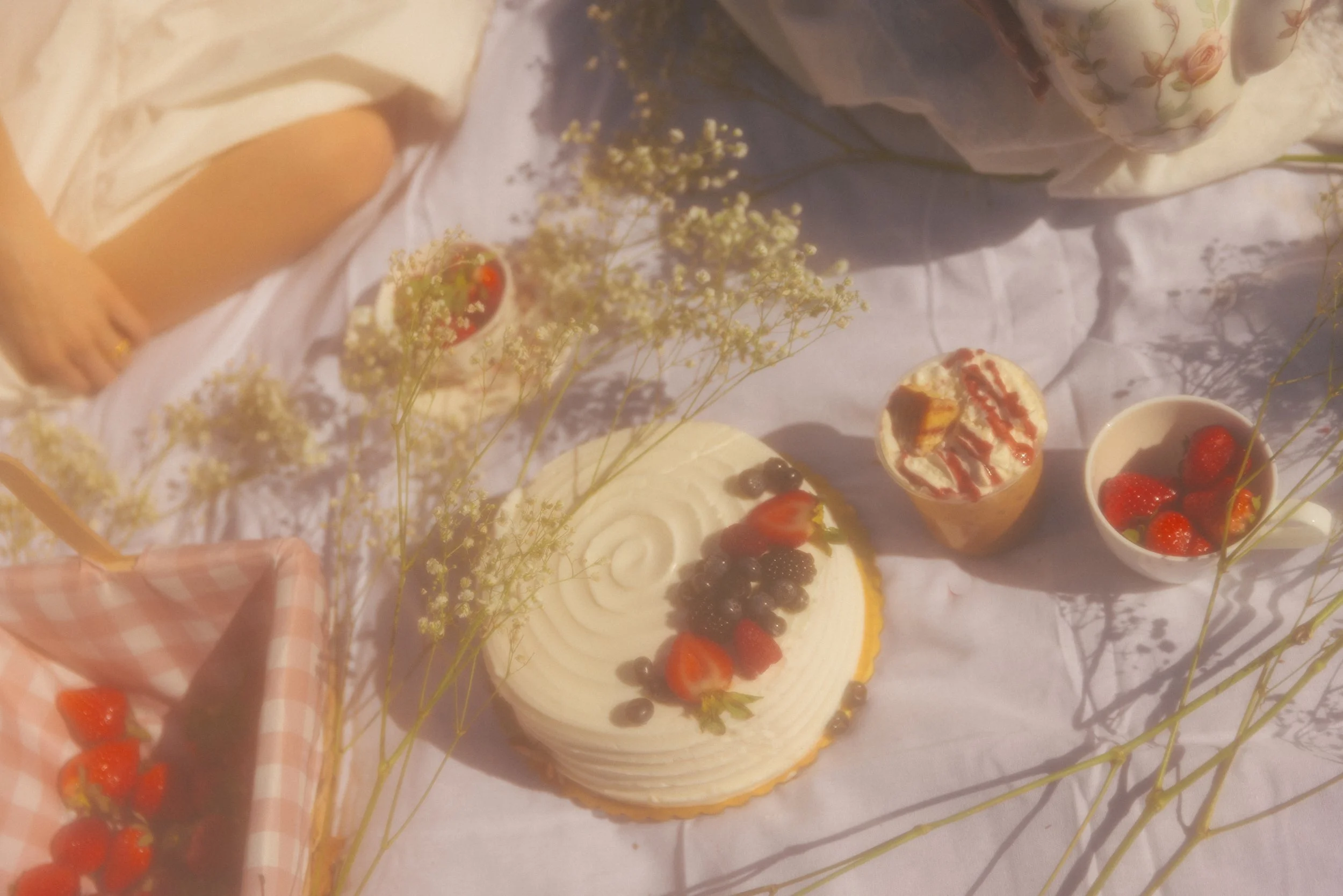Various desserts and strawberries on a table with floral decorations.