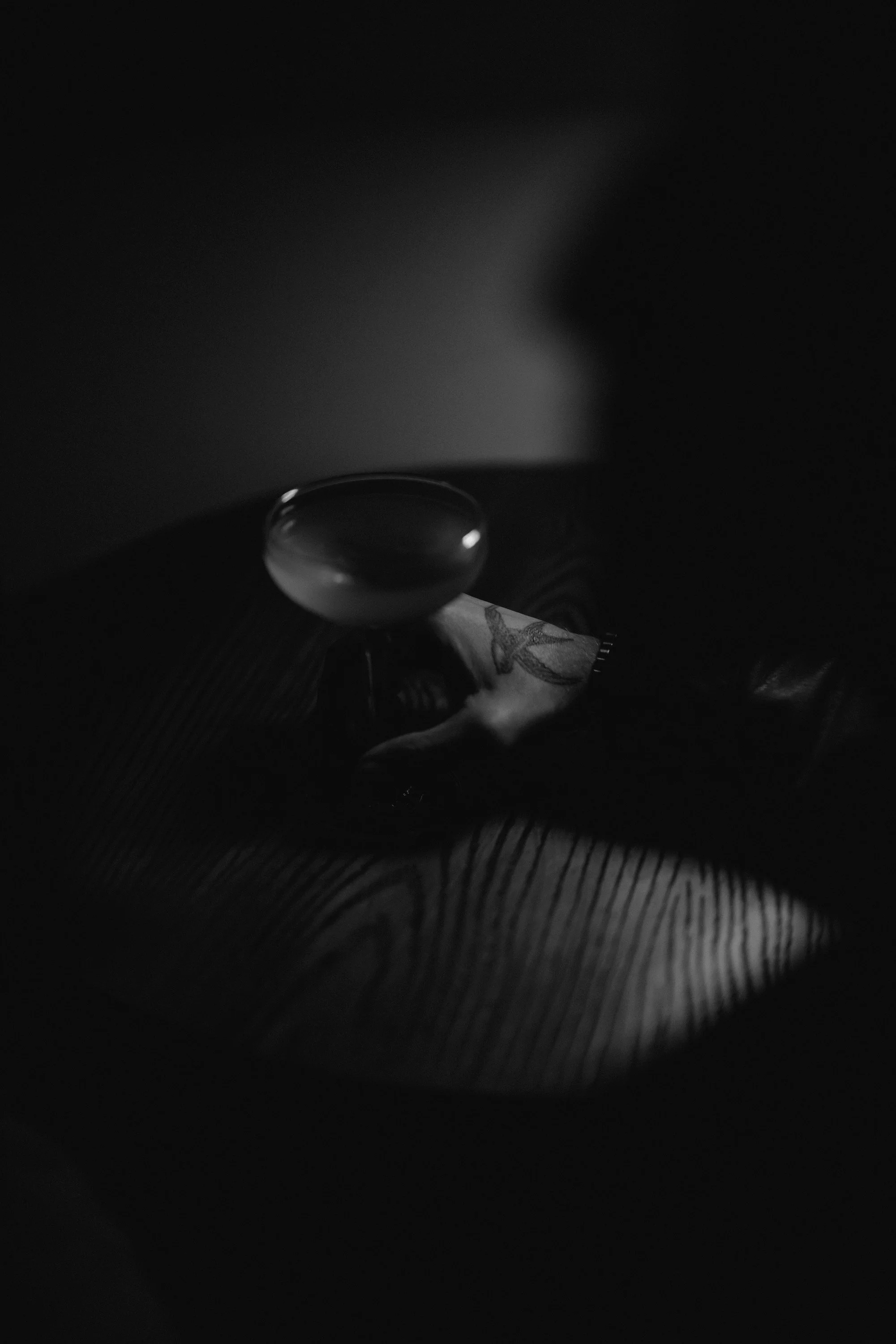A dark, dimly lit scene showing a water bottle, a cloth with a leaf pattern, and a keypad on a textured surface.