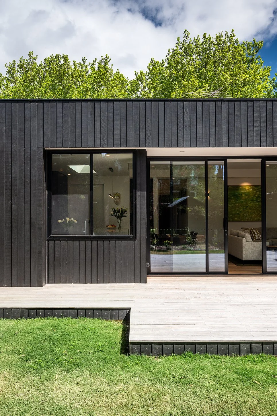 Black timber cladding rear extension with deck and sliding doors