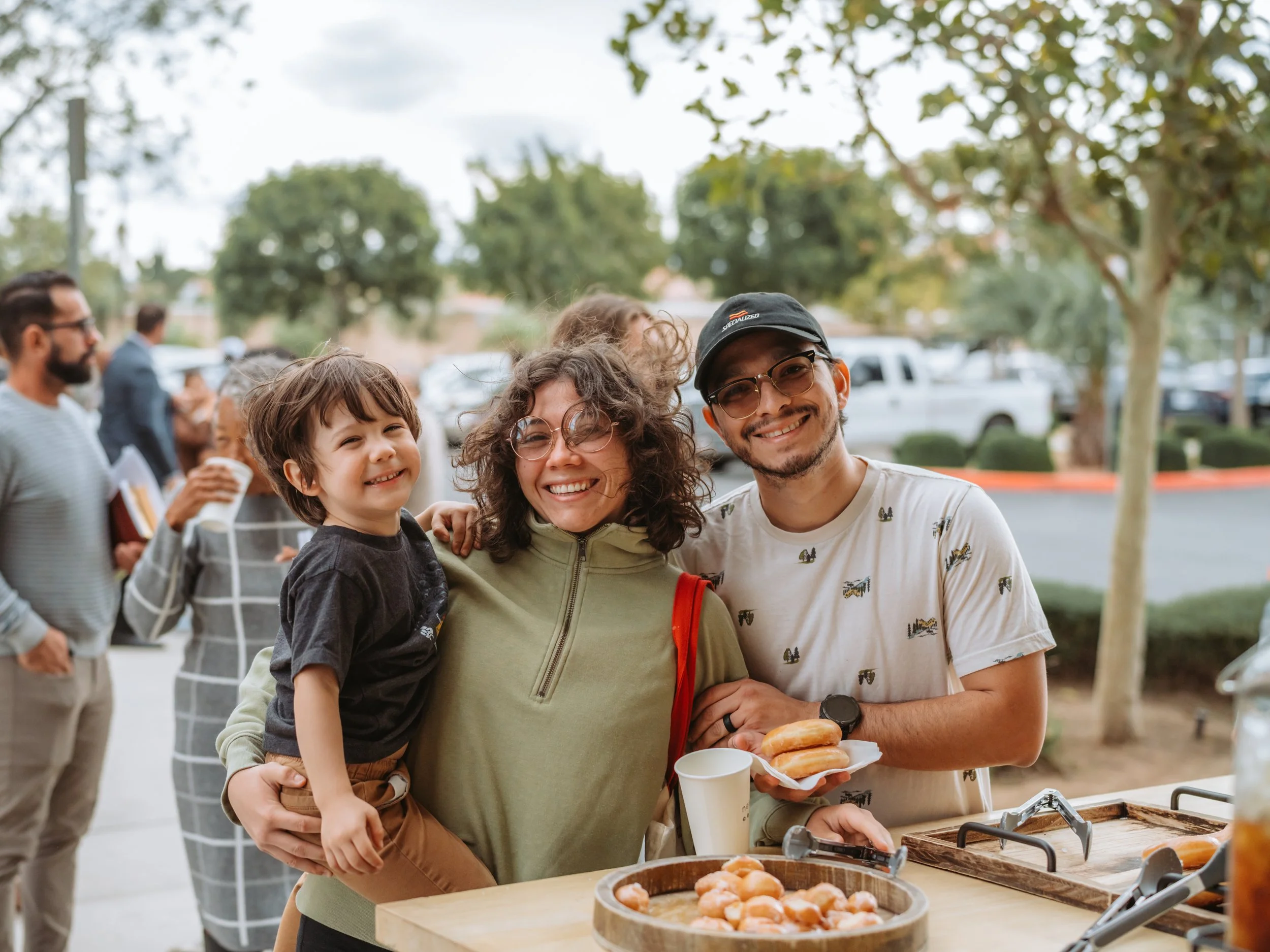 Image of a family smiling and getting coffee before the worship service begins.