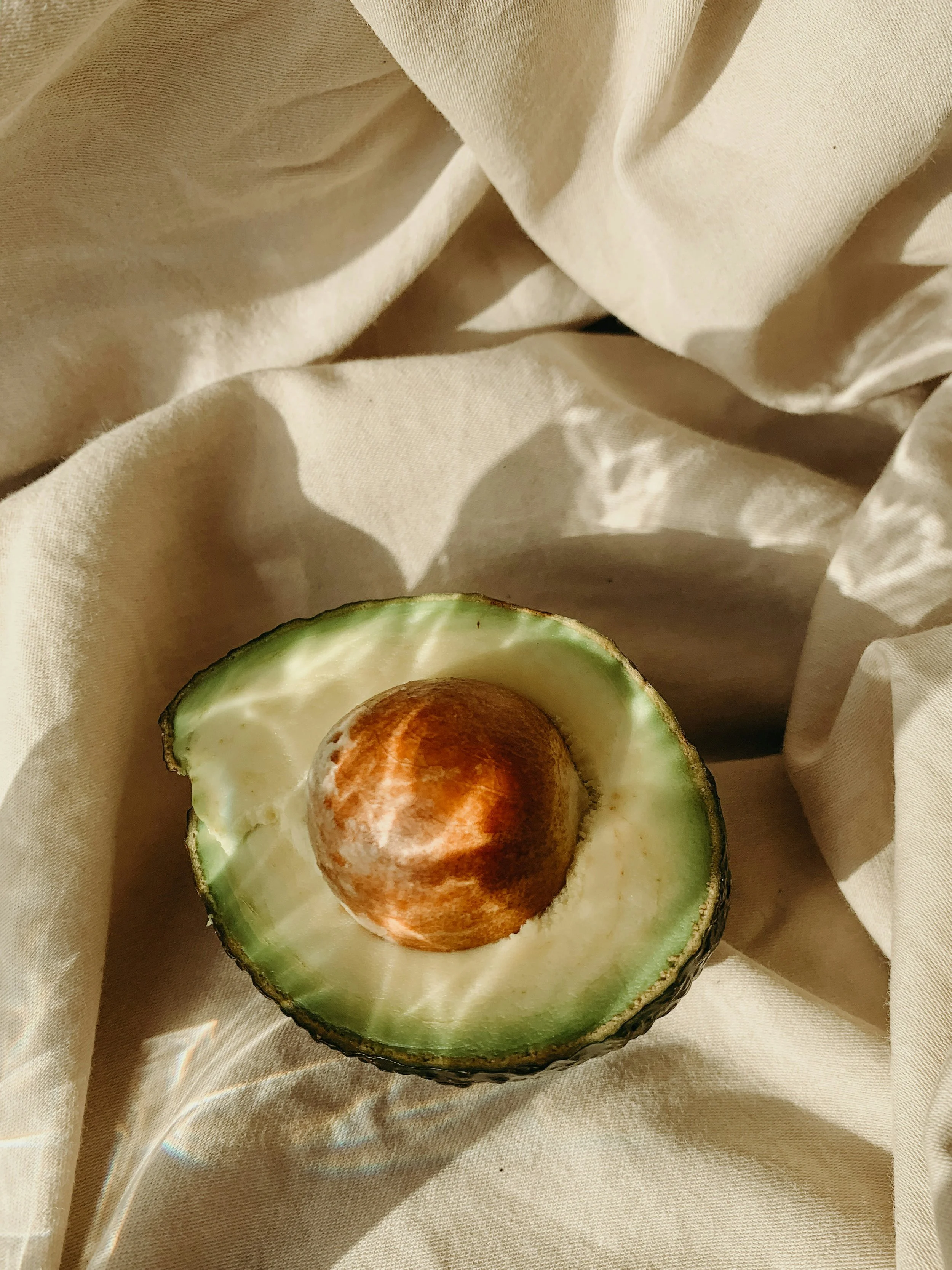 half an avocado on brown linen cloth