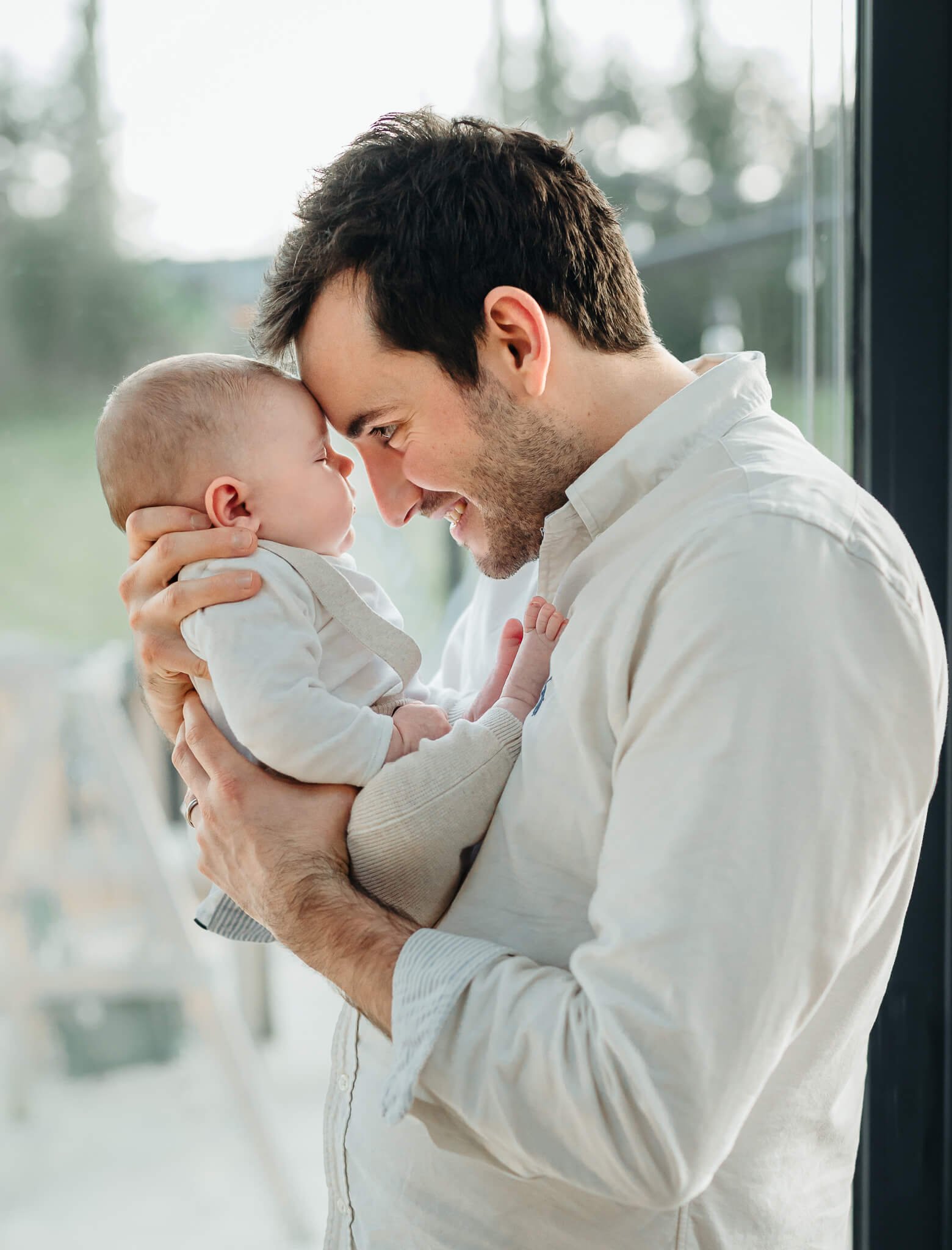 Dad leaning in and looking at baby