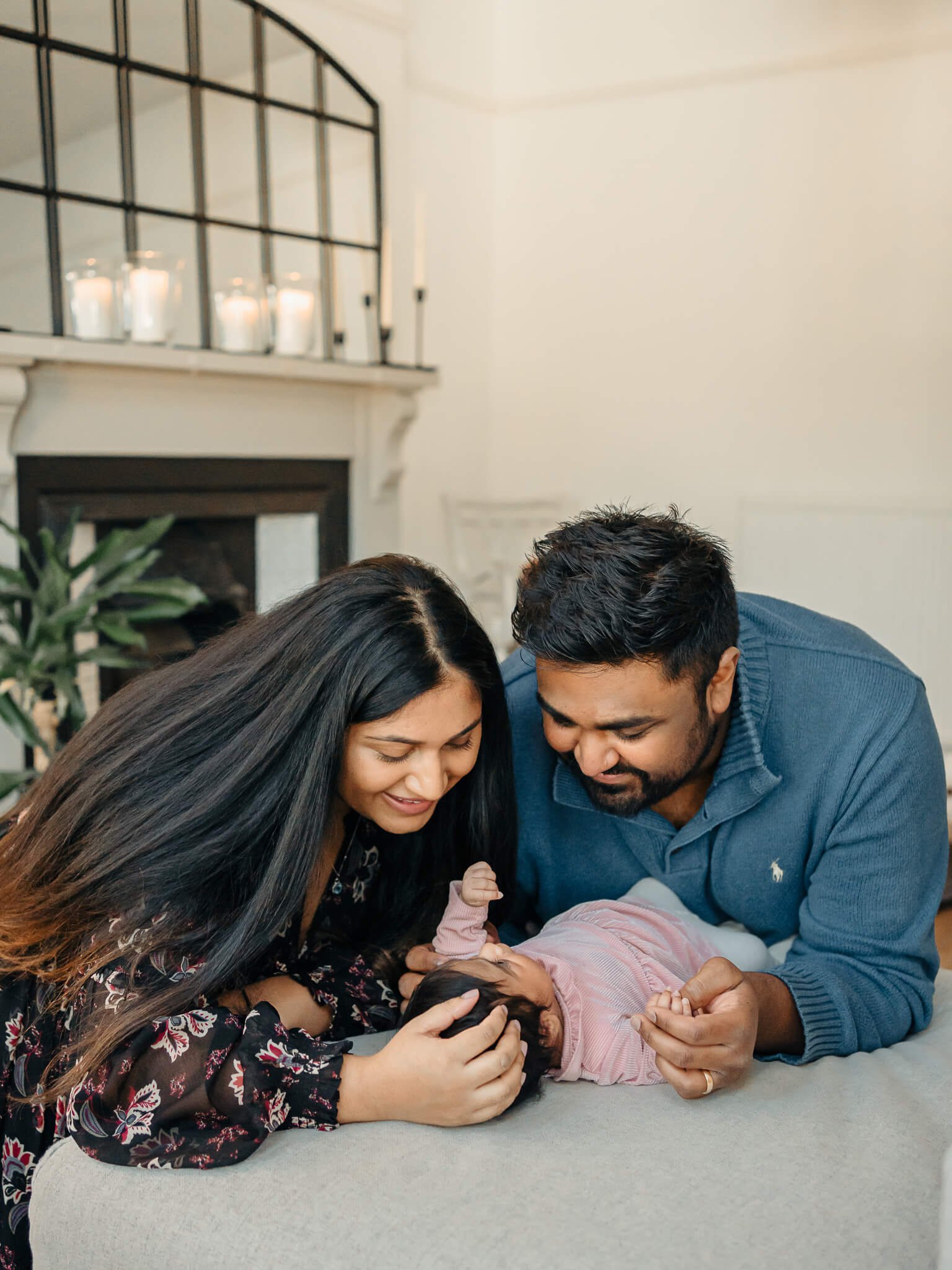 Mum and dad staring down at baby daughter 