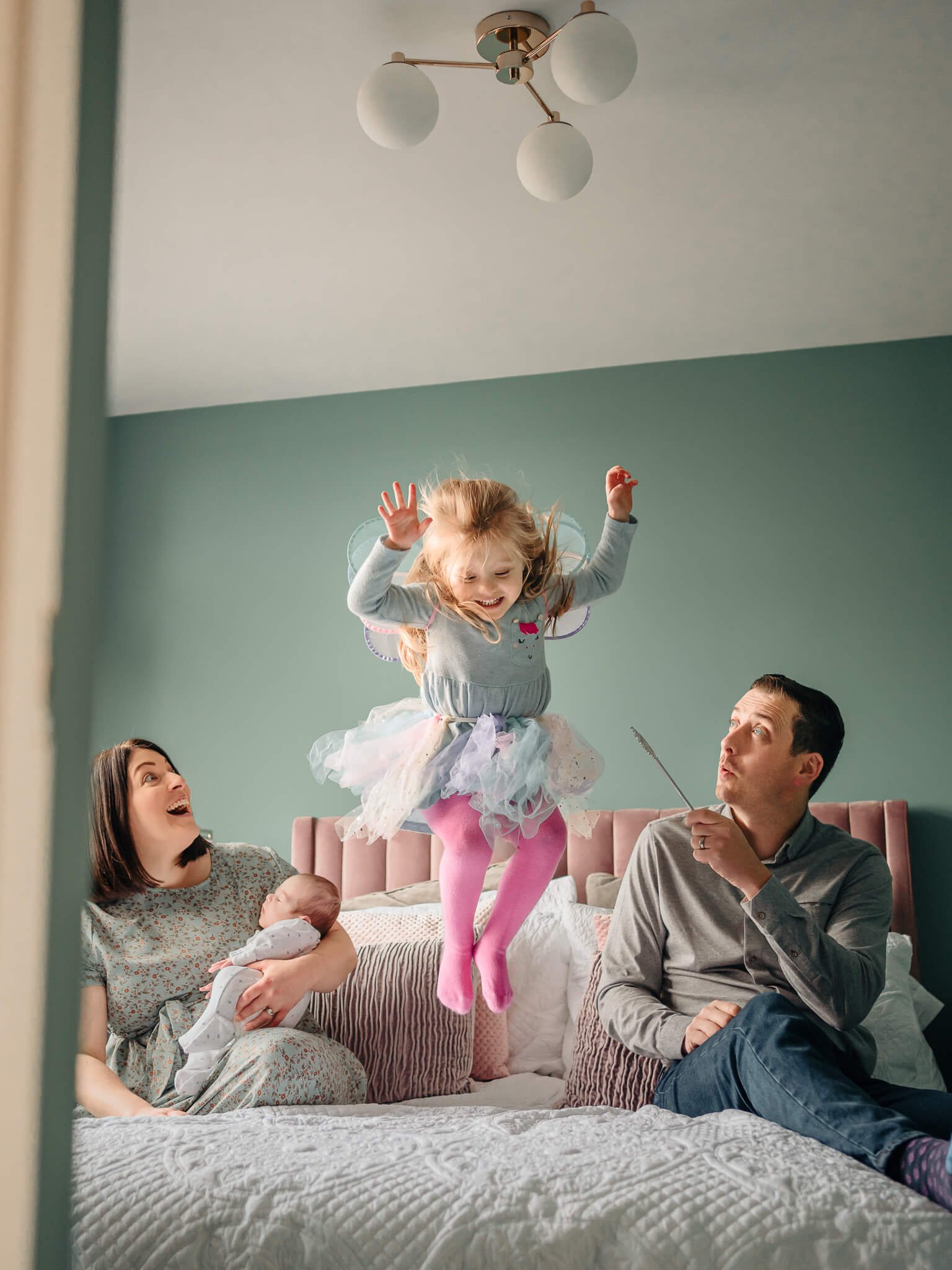 Little girl jumping on bed in tutu