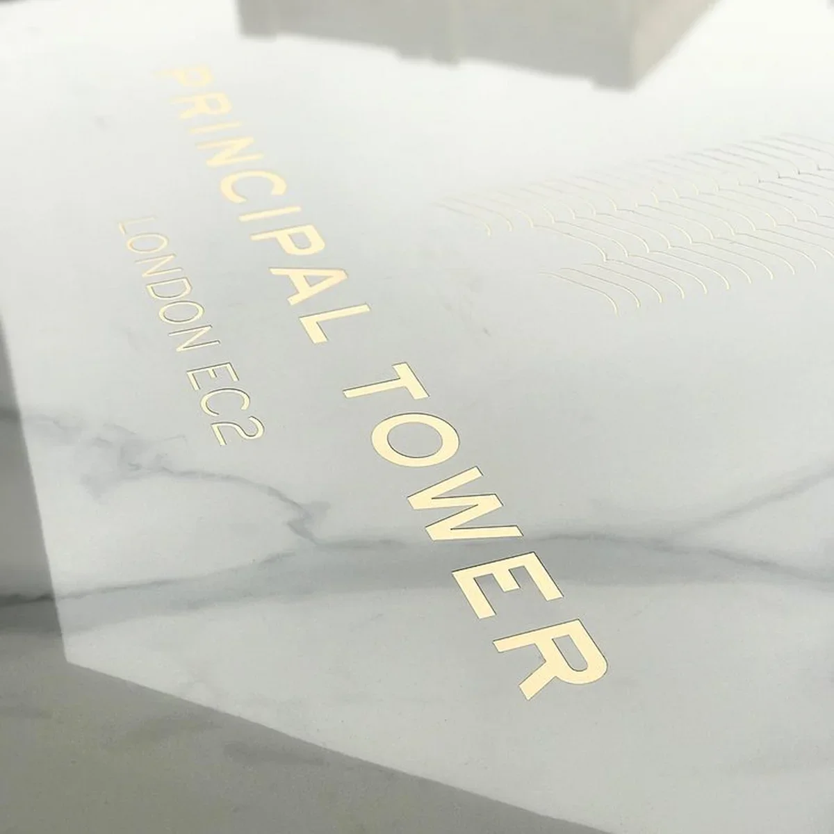 Detail of bespoke Principal Tower London EC2 signage with etched gold lettering on a stone finish, featured in a Southside case study.